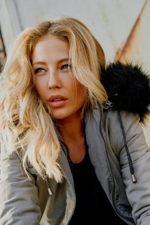 Modelbild-Dame mit langen blonden Harren trägt eine Winterjacke