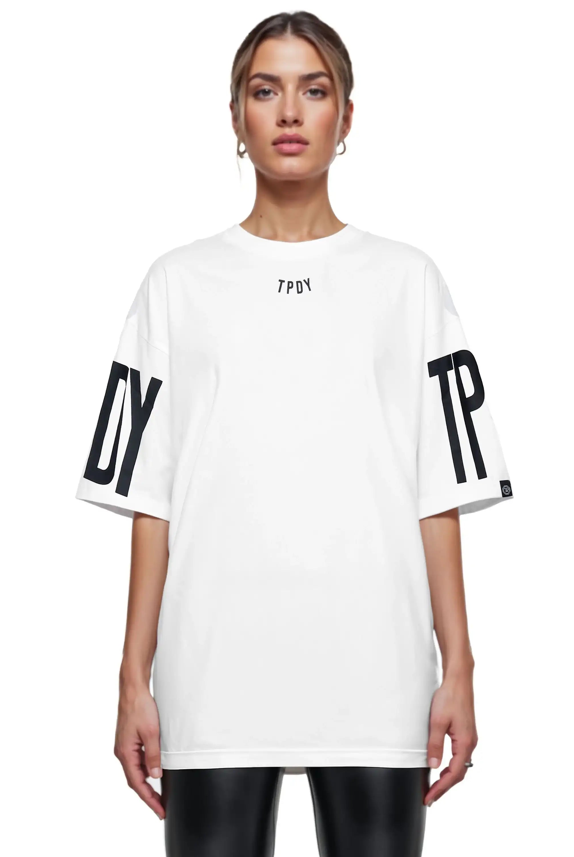 Eine Person trägt ein lockeres Viktor F Oversize-Damen-T-Shirt von trueprodigy mit Ärmelprints und Frontprint unter dem Kragen, kombiniert mit einer schwarzen Hose, vor weißem Hintergrund.