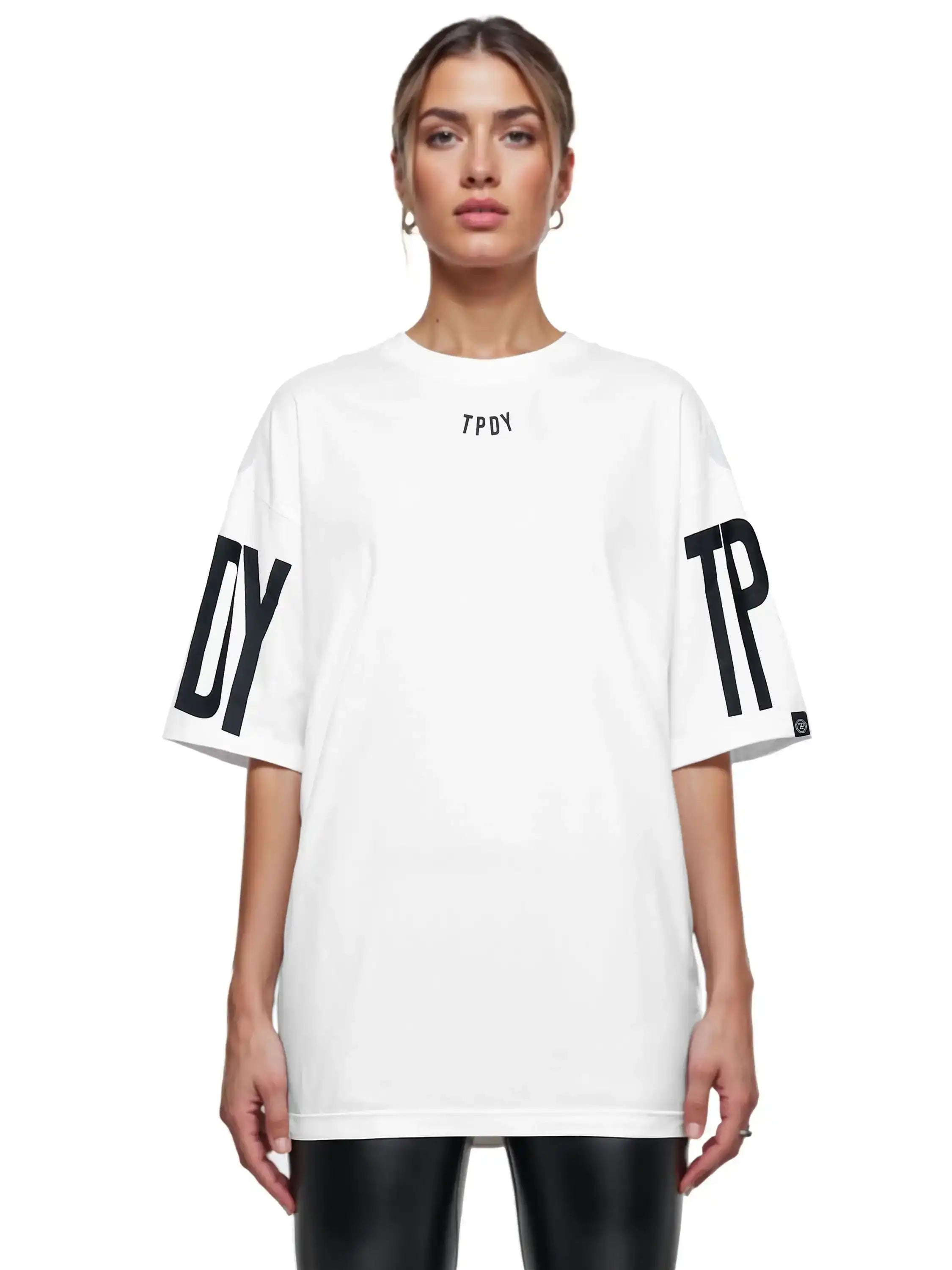 Eine Person trägt ein lockeres Viktor F Oversize-Damen-T-Shirt von trueprodigy mit Ärmelprints und Frontprint unter dem Kragen, kombiniert mit einer schwarzen Hose, vor weißem Hintergrund.