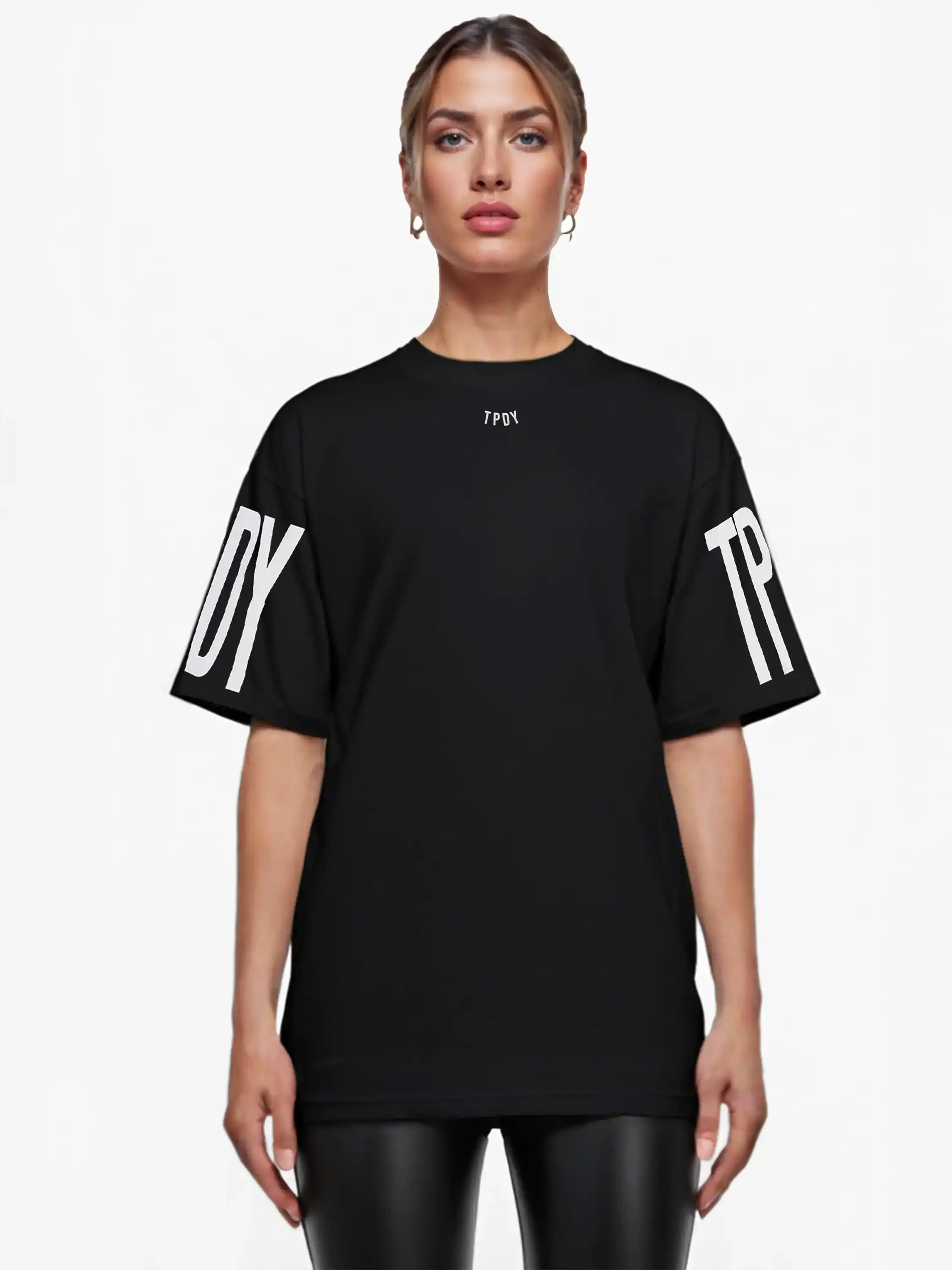 Eine Person blickt nach vorne und trägt das trueprodigy Viktor F Oversize-Damen-T-Shirt mit dezentem Frontprint unter dem Kragen und auffälligen Ärmeldrucken; sie hat glattes Haar zurückgesteckt und ist mit Ohrringen geschmückt.