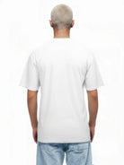 Abgebildet ist eine Person mit kurzen, hellblonden Haaren von hinten, die das trueprodigy Noa Oversize-Shirt mit "FEAR NOTHING"-Print & handschriftlichem Detail und hellblaue Jeans vor weißem Hintergrund trägt.