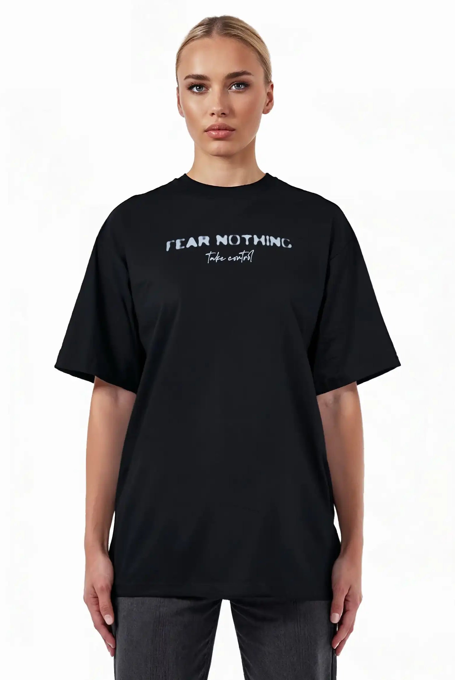 Auf dem trueprodigy Noa F Oversize-T-Shirt mit "FEAR NOTHING" & "take control" Frontprint aus schwerem Jersey blickt eine Person nach vorne. Das Unisex-Shirt hebt sich von einem weißen Hintergrund ab, gestylt mit einer dunklen Hose.