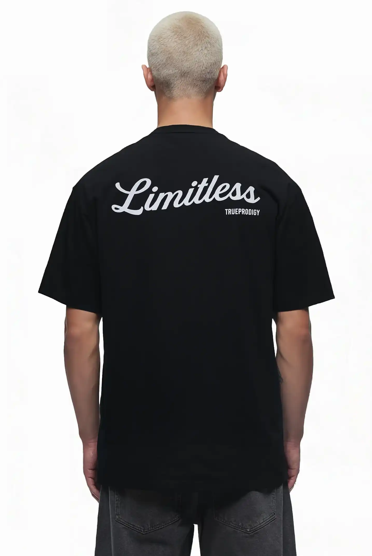 Eine Person mit kurzen, hellen Haaren ist von hinten in einem Kai Oversize-Herren-T-Shirt von trueprodigy zu sehen, das auf dem oberen Rücken mit "LIMITLESS" bedruckt ist. Das T-Shirt ist aus dickerem Jersey-Stoff gefertigt, der Hintergrund ist einfarbig weiß.