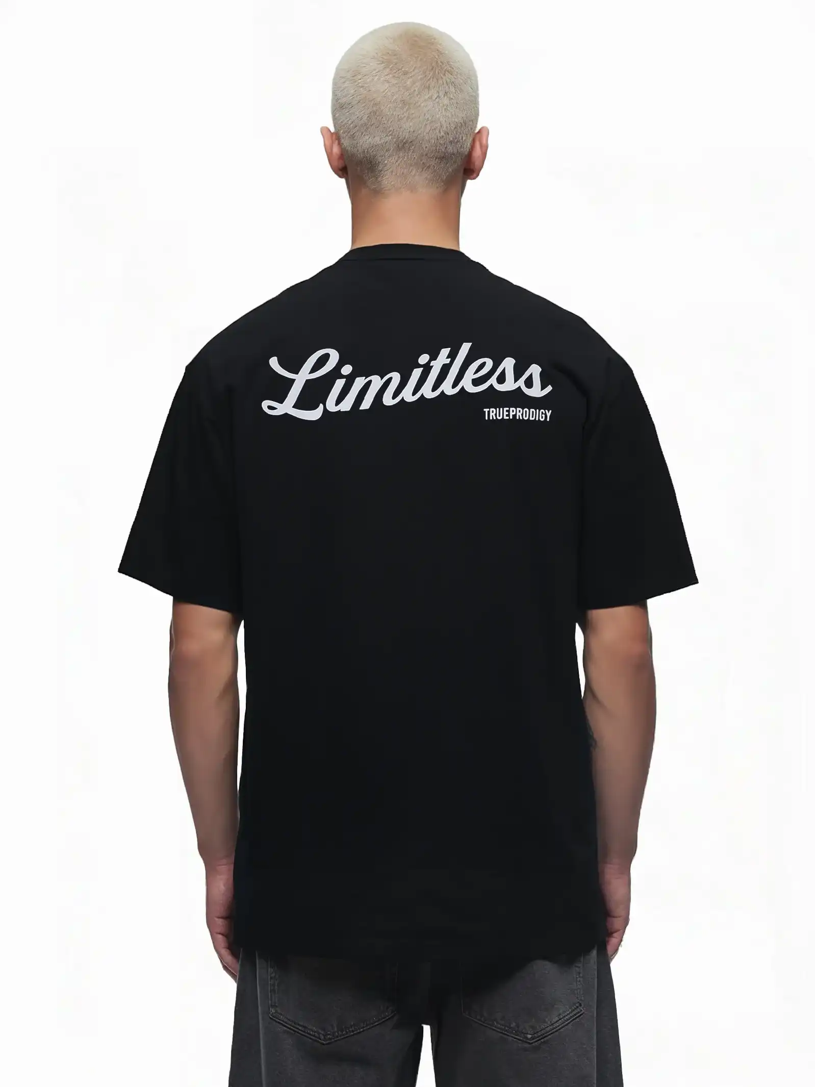 Eine Person mit kurzen, hellen Haaren ist von hinten in einem Kai Oversize-Herren-T-Shirt von trueprodigy zu sehen, das auf dem oberen Rücken mit "LIMITLESS" bedruckt ist. Das T-Shirt ist aus dickerem Jersey-Stoff gefertigt, der Hintergrund ist einfarbig weiß.