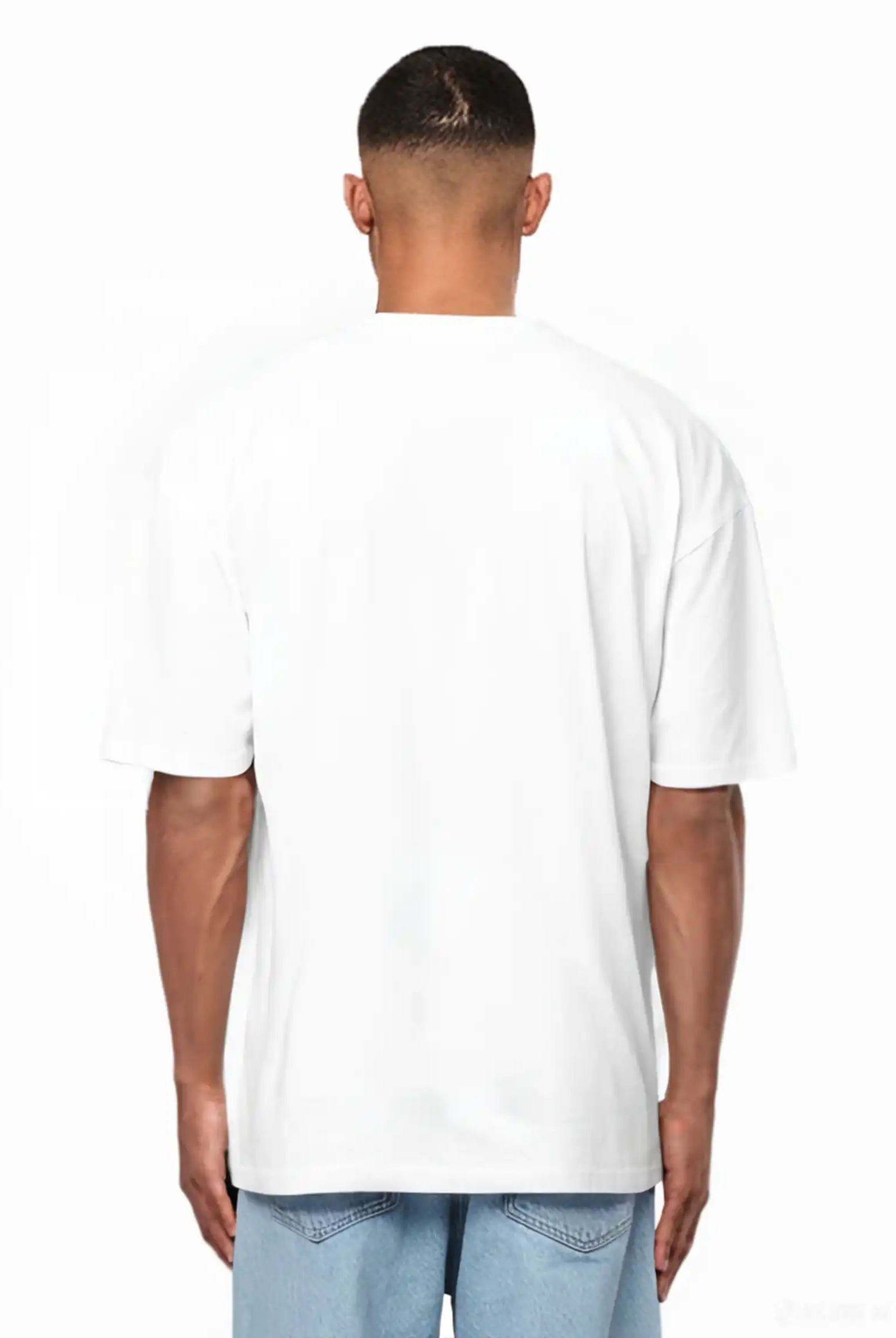 Eine Person steht von der Kamera abgewandt, trägt ein weißes Ravi Oversize-Shirt mit großem trueprodigy-Schriftzug vorn by trueprodigy und hellblaue Jeans vor weißem Hintergrund.