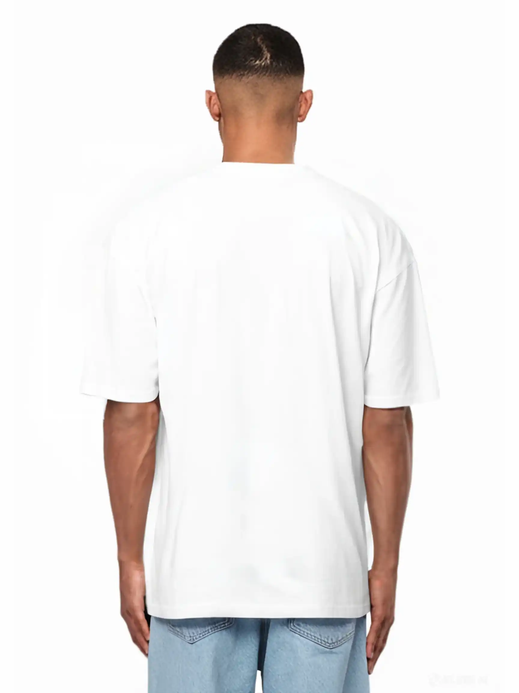 Eine Person steht von der Kamera abgewandt, trägt ein weißes Ravi Oversize-Shirt mit großem trueprodigy-Schriftzug vorn by trueprodigy und hellblaue Jeans vor weißem Hintergrund.