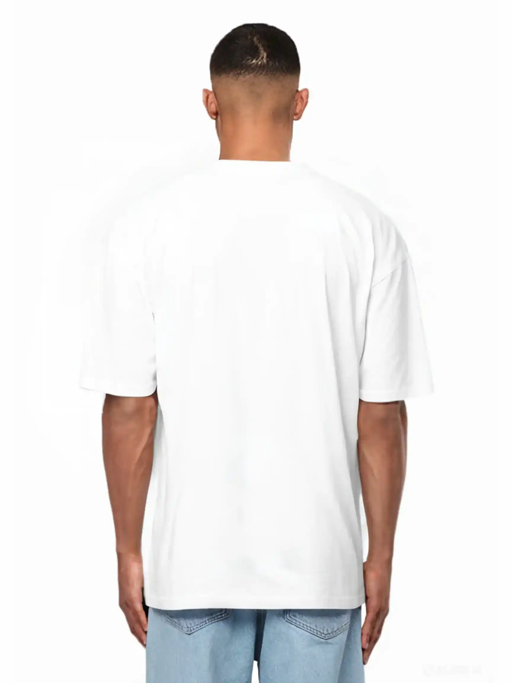 Eine Person steht von der Kamera abgewandt, trägt ein weißes Ravi Oversize-Shirt mit großem trueprodigy-Schriftzug vorn by trueprodigy und hellblaue Jeans vor weißem Hintergrund.