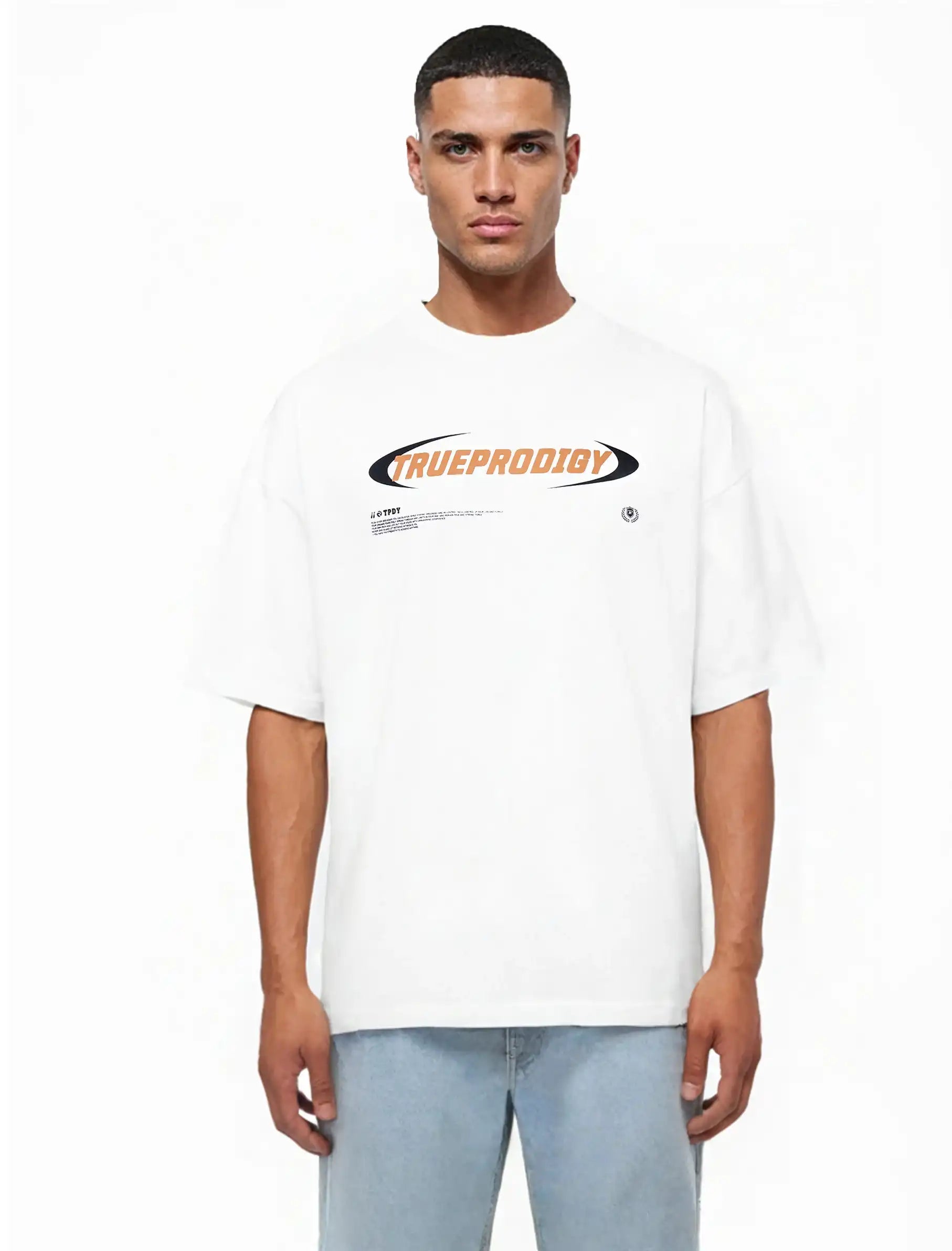Ein Mann blickt nach vorne und trägt das trueprodigy "Ravi Oversize-Shirt mit großem trueprodigy-Schriftzug vorn" in Weiß mit auffälligem orange-schwarzem Branding auf der Brust, gestylt mit hellblauen Jeans.