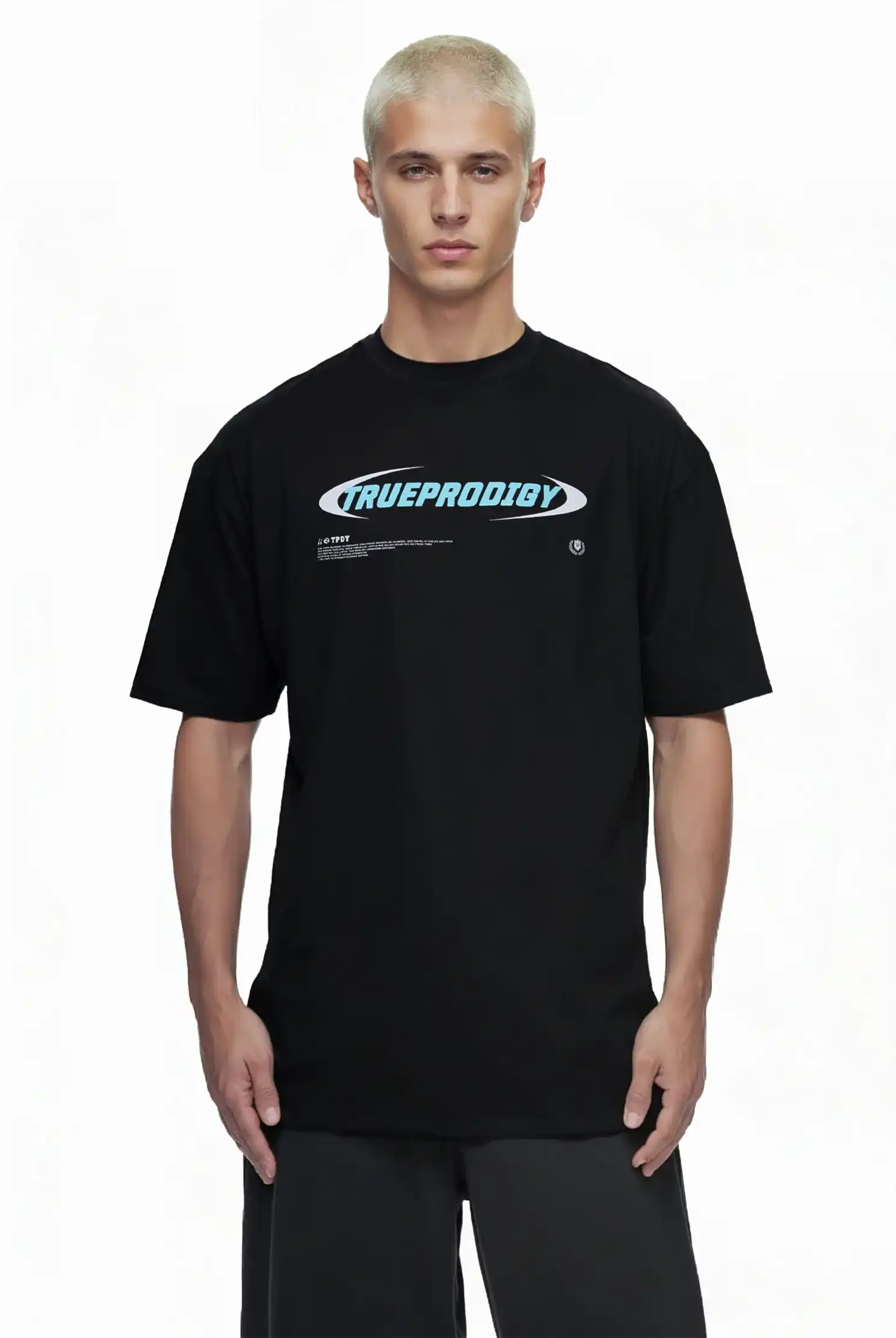 Eine Person mit kurzen gebleachten blonden Haaren trägt das trueprodigy Ravi Oversize-Shirt mit einem großen trueprodigy-Schriftzug vorne, aus schwerem Jersey Stoff. Der Hintergrund ist einfarbig weiß.