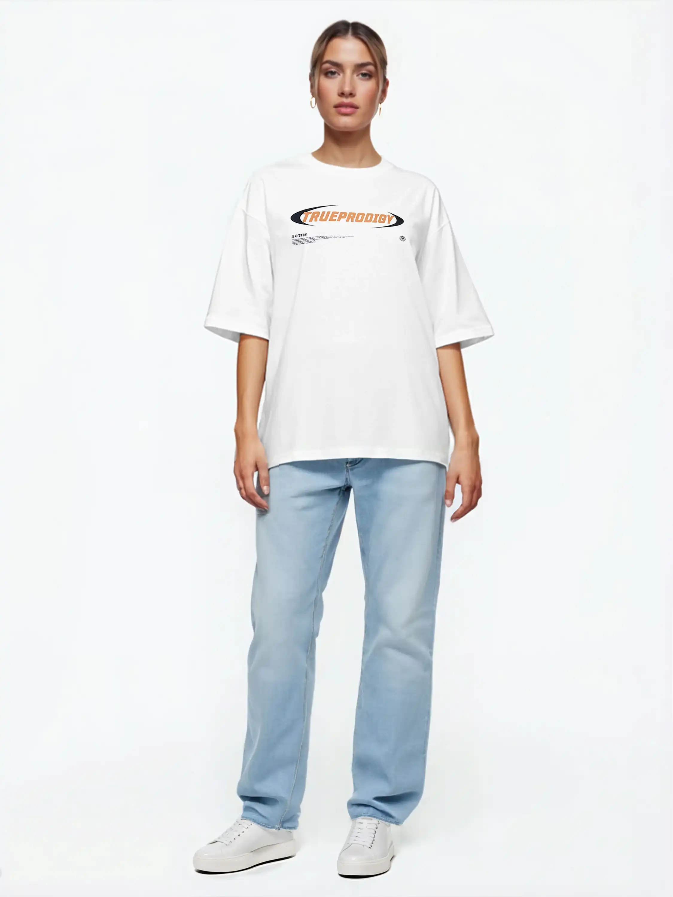 Eine Person steht vor einem schlichten weißen Hintergrund, trägt das trueprodigy Ravi F Oversize-T-Shirt mit farbigem TRUEPRODIGY-Frontprint, hellblaue Jeans und weiße Turnschuhe, die Arme an der Seite und einen neutralen Gesichtsausdruck.