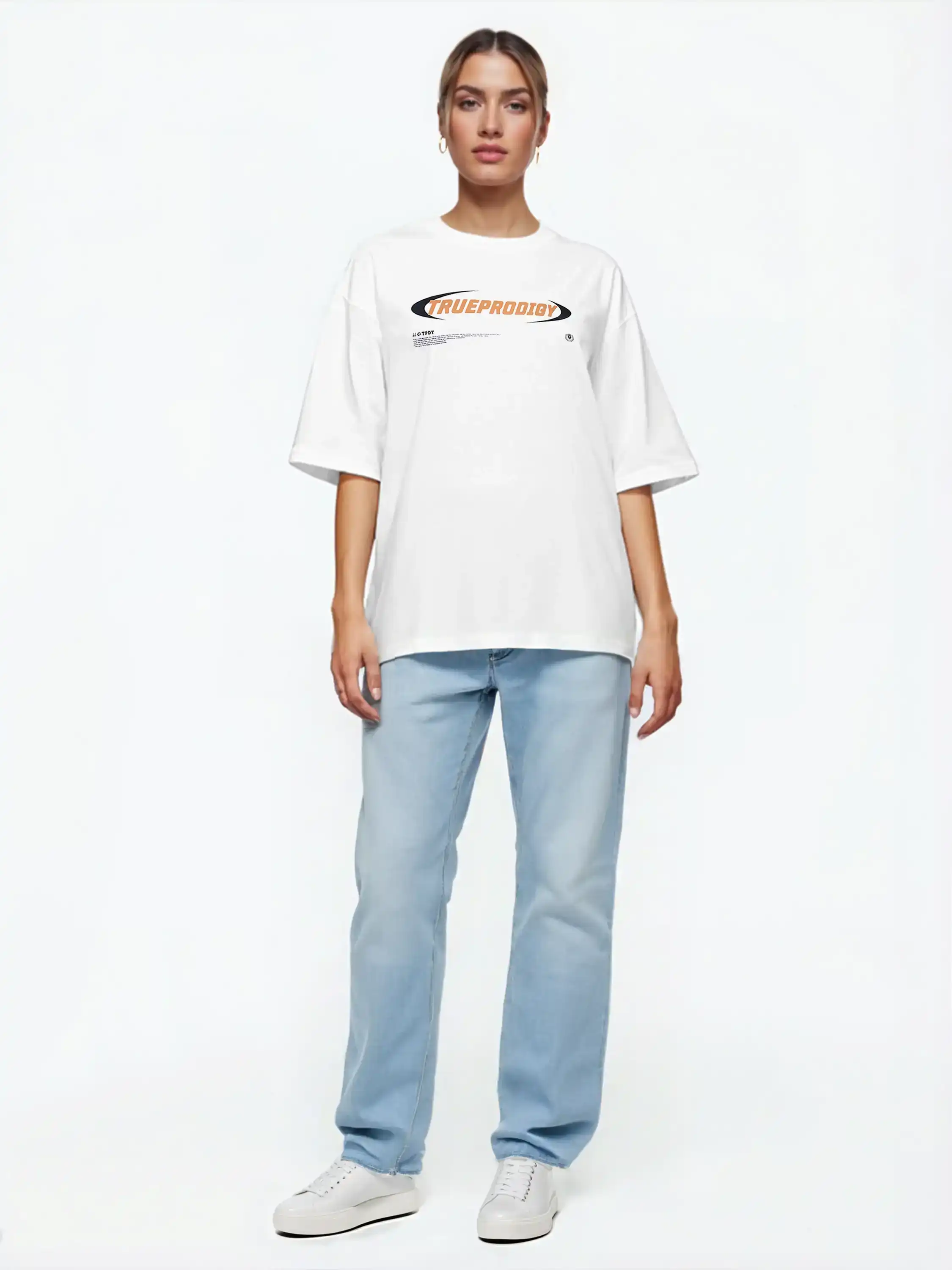 Eine Person steht vor einem schlichten weißen Hintergrund, trägt das trueprodigy Ravi F Oversize-T-Shirt mit farbigem TRUEPRODIGY-Frontprint, hellblaue Jeans und weiße Turnschuhe, die Arme an der Seite und einen neutralen Gesichtsausdruck.