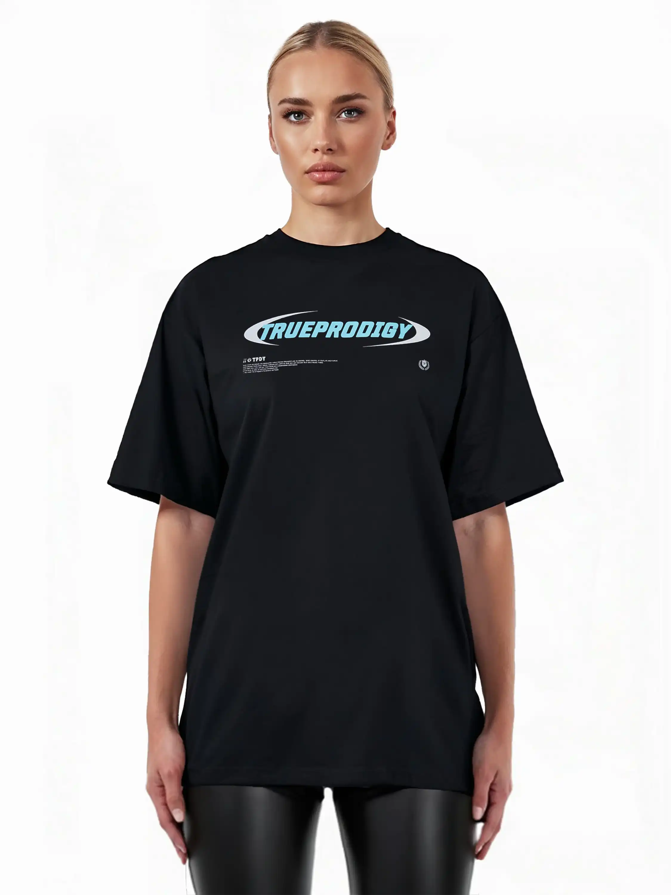 Eine Person steht mit dem Blick nach vorne und trägt das trueprodigy Ravi F Oversize-T-Shirt mit buntem TRUEPRODIGY-Frontprint aus dickem Jersey-Stoff, gepaart mit einer schwarzen Hose in Lederoptik vor einem schlichten weißen Hintergrund.