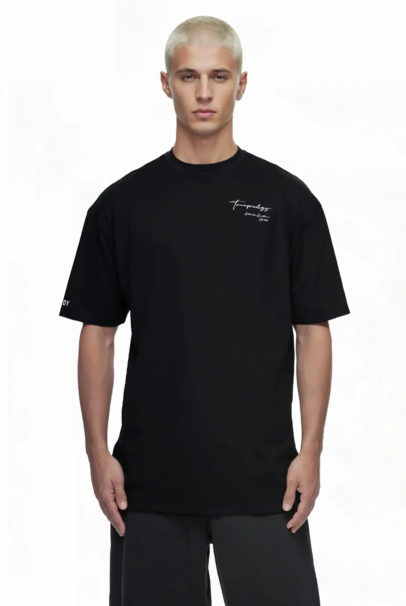 Eine Person mit kurzen, gebleichten blonden Haaren modelliert das trueprodigy Marin Oversize-T-Shirt mit edlem Schriftzug auf der Brust, mit kleiner weißer Schrift, vor einem schlichten weißen Hintergrund.