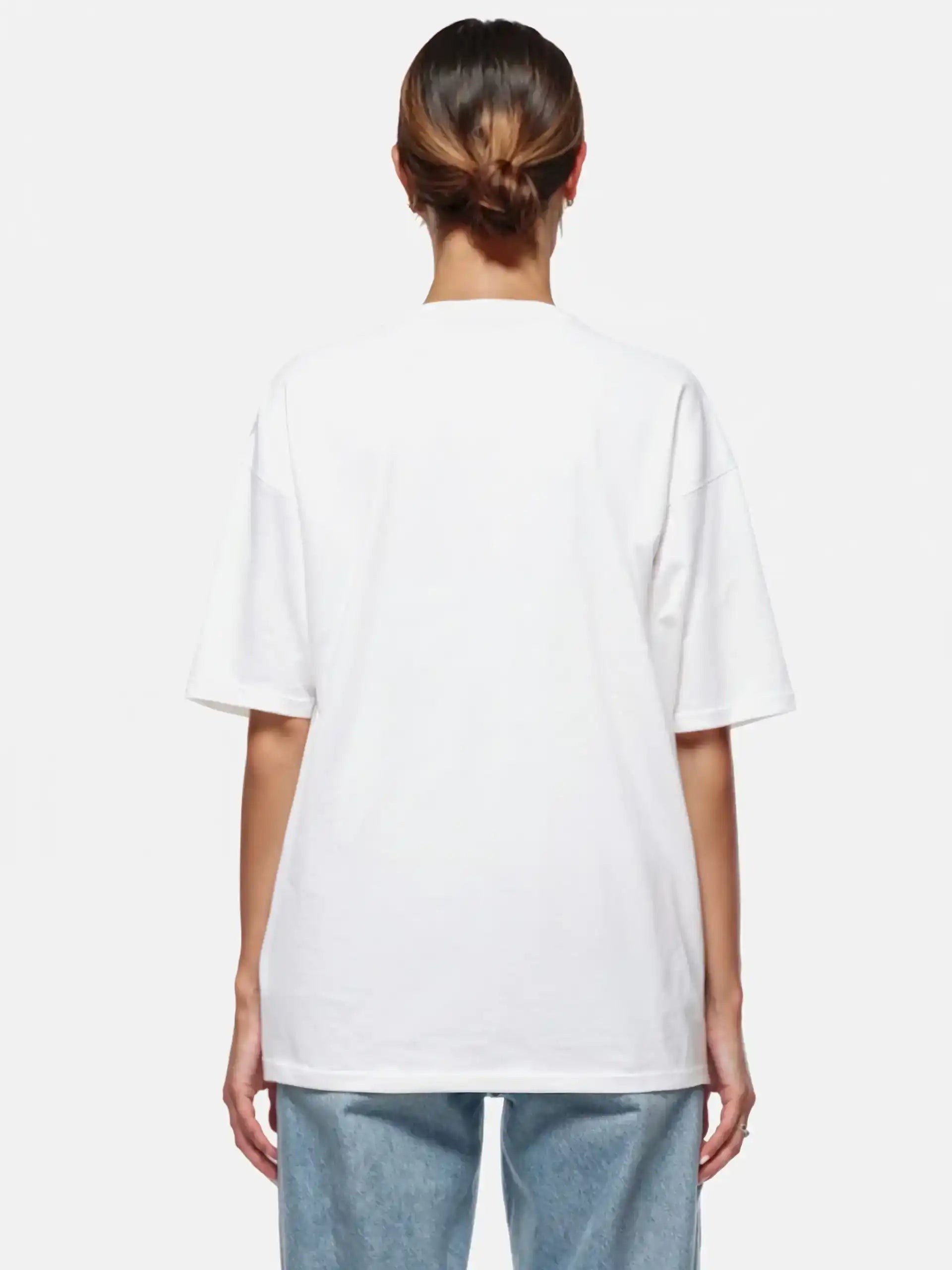 Gezeigt wird eine Person mit zurückgebundenem Haar von hinten, die das trueprodigy Marin F Oversize-T-Shirt mit feiner Logo-Schrift & TPDY-Print am Ärmel in weiß und hellblauer Jeans vor weißem Hintergrund trägt.