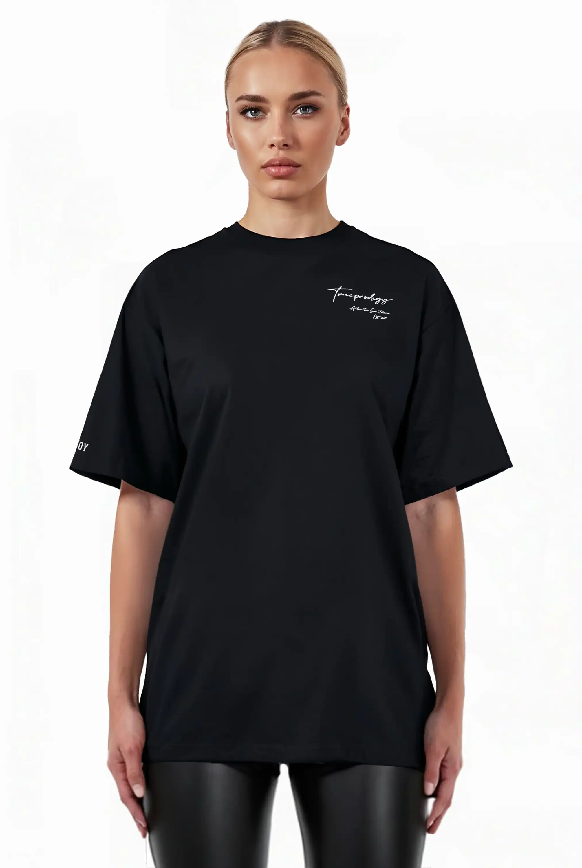 Eine Person mit zurückgesteckten blonden Haaren trägt das trueprodigy Marin F Oversize-T-Shirt mit feiner Logo-Schrift & TPDY-Print am Ärmel, gepaart mit einer schwarzen Kunstlederhose, vor einem schlichten weißen Hintergrund.