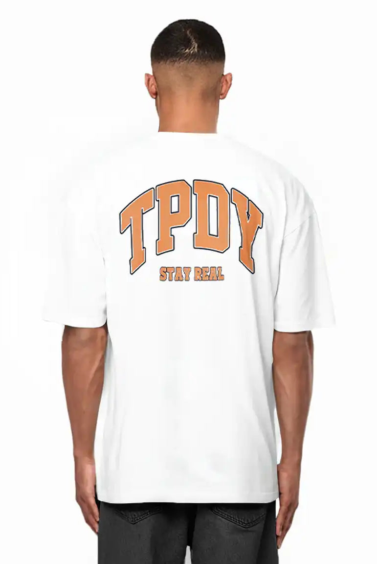 Eine Person trägt das trueprodigy Arin Oversize-Shirt mit auffälligem orangenem TPDY-Logo und "Stay Real"-Rückenprint, gestylt mit dunklen Shorts.