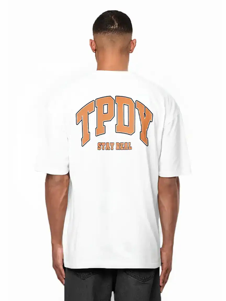 Eine Person trägt das trueprodigy Arin Oversize-Shirt mit auffälligem orangenem TPDY-Logo und "Stay Real"-Rückenprint, gestylt mit dunklen Shorts.