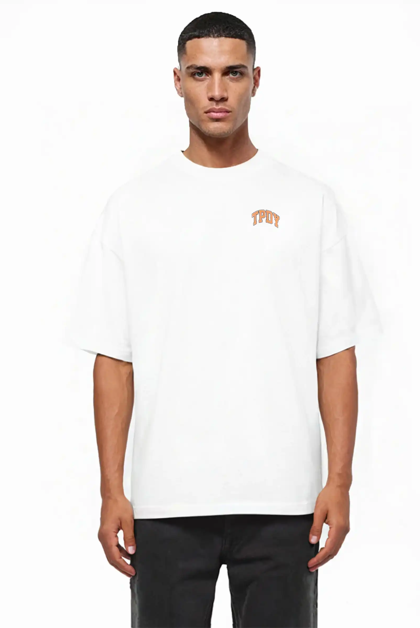 Ein Mann steht vor einem schlichten weißen Hintergrund und trägt das trueprodigy Oversize-Shirt mit TPDY-Logo & Rückenprint "Stay Real" in schwerem Jerseystoff und schwarzer Hose.