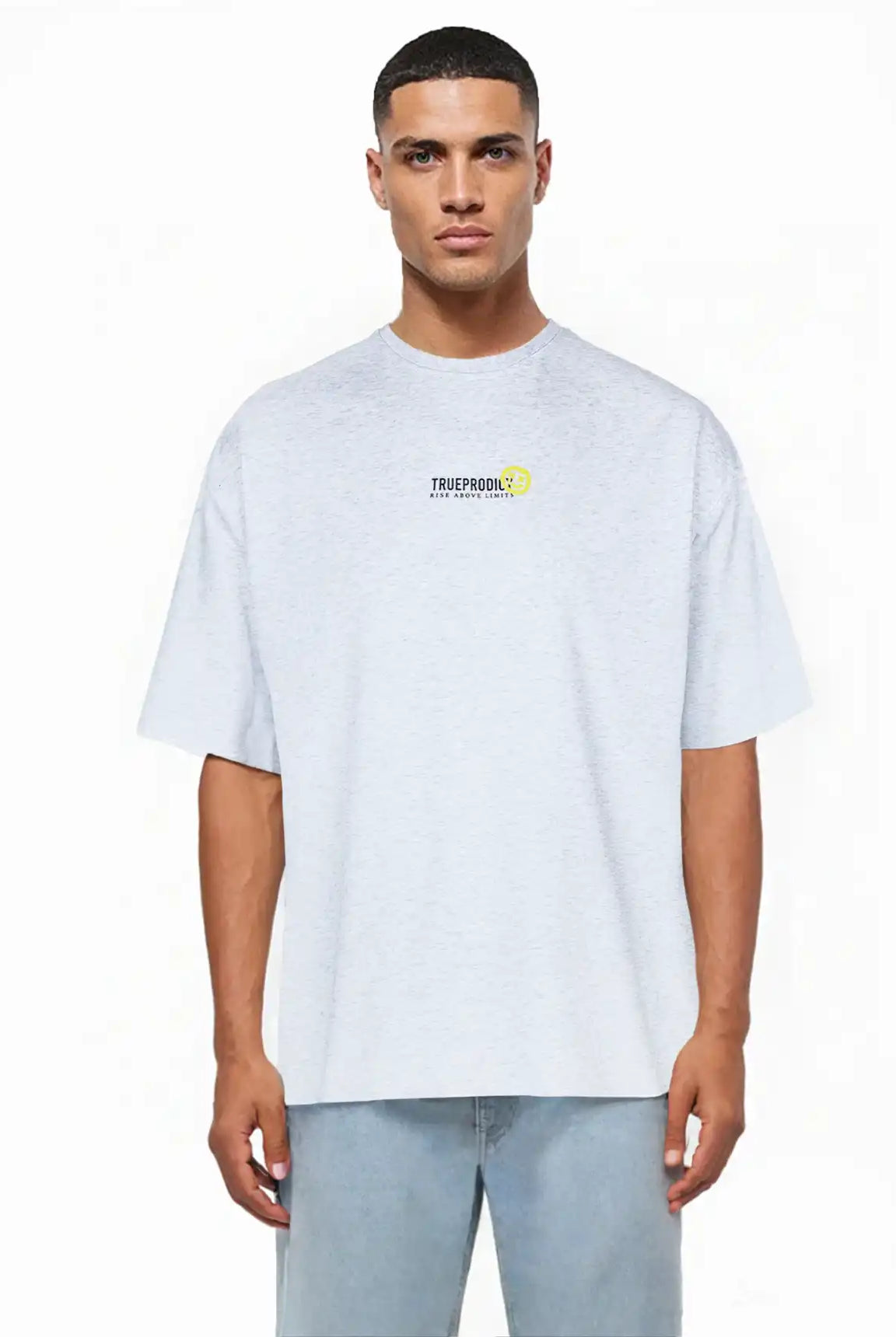Ein Mann blickt nach vorne in einem hellgrauen trueprodigy Oversize-Herren-T-Shirt mit Logo-Smile-Grafik auf der Brust aus schwerem Jerseystoff, gepaart mit hellblauen Jeans, vor einem schlichten weißen Hintergrund.