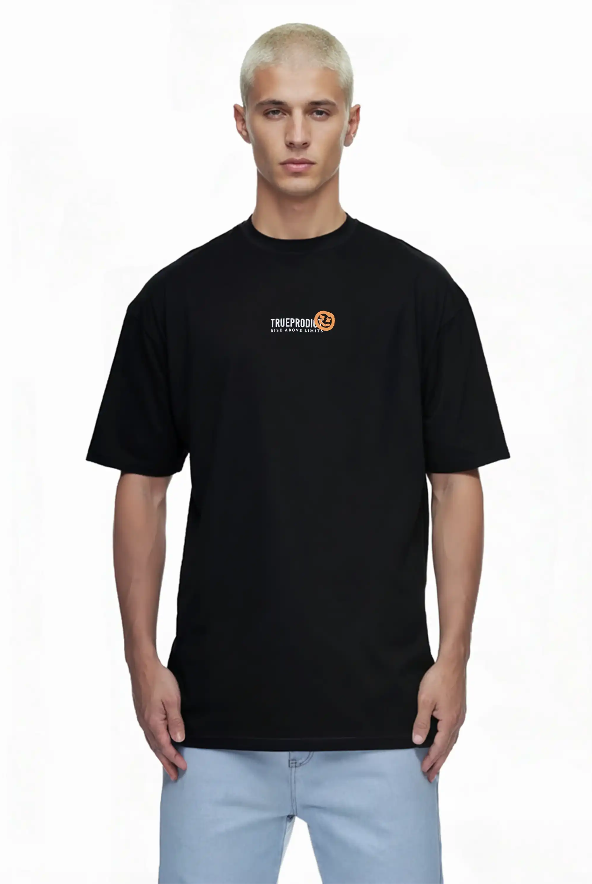 Eine Person mit kurzen, gebleichten blonden Haaren trägt ein trueprodigy Oversize-Herren-T-Shirt mit Logo-Smile-Grafik auf der Brust und hellblaue Jeans und steht vor einem schlichten weißen Hintergrund.