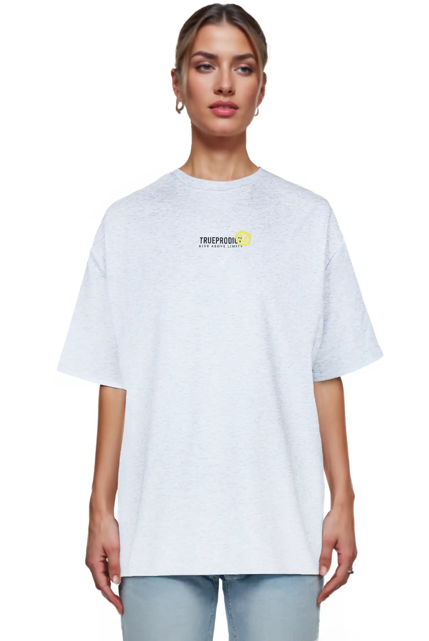 Eine Person blickt nach vorne in einem hellgrauen Juniper F Oversize-Damen-T-Shirt von trueprodigy mit einer kleinen Logo-Smile-Grafik auf der Brust, gepaart mit hellblauen Jeans. Der Hintergrund ist einfarbig weiß.