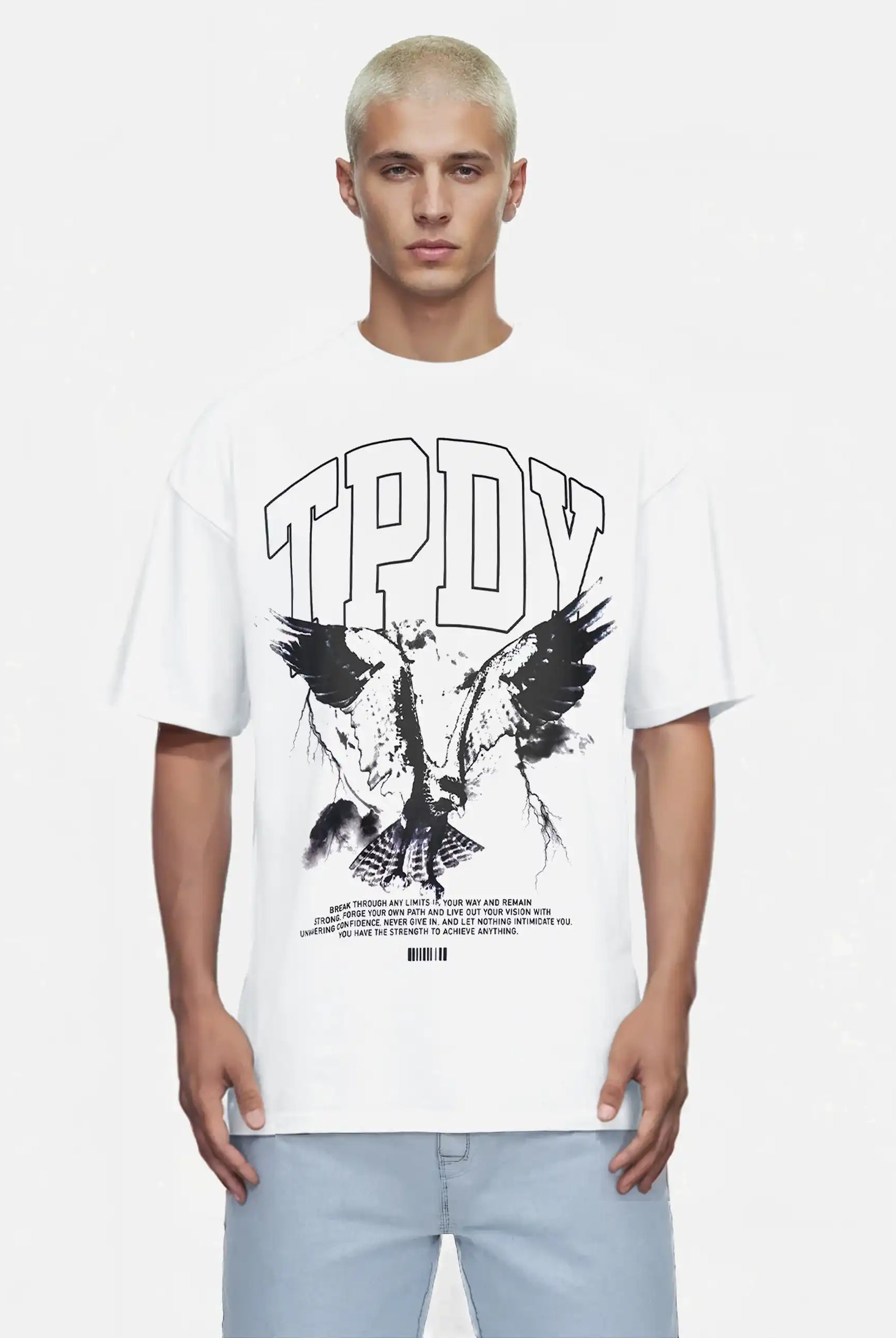 Eine Person mit kurzen blonden Haaren trägt das trueprodigy Yuki Oversize-T-Shirt mit Adlergrafik & TPDY-Schriftzug in weiß, gepaart mit hellblauen Jeans, vor einem schlichten Hintergrund.