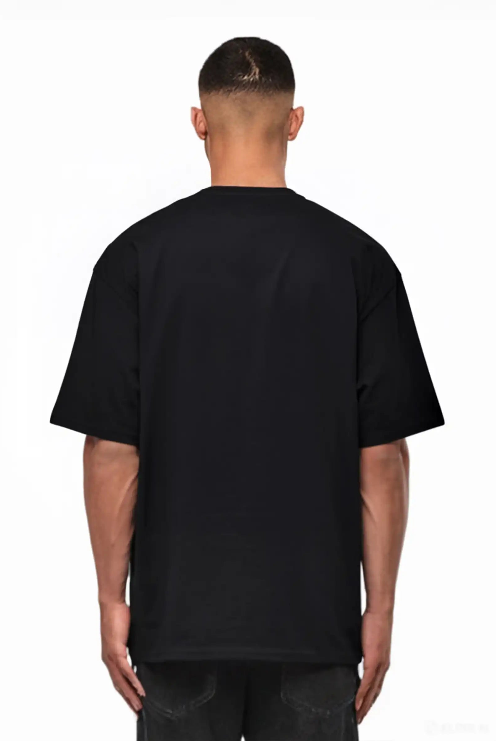 Eine Person steht mit dem Rücken zur Kamera, trägt ein trueprodigy Yuki Oversize-T-Shirt mit Adlergrafik & TPDY-Schriftzug und dunkle Jeans vor einem weißen Hintergrund.