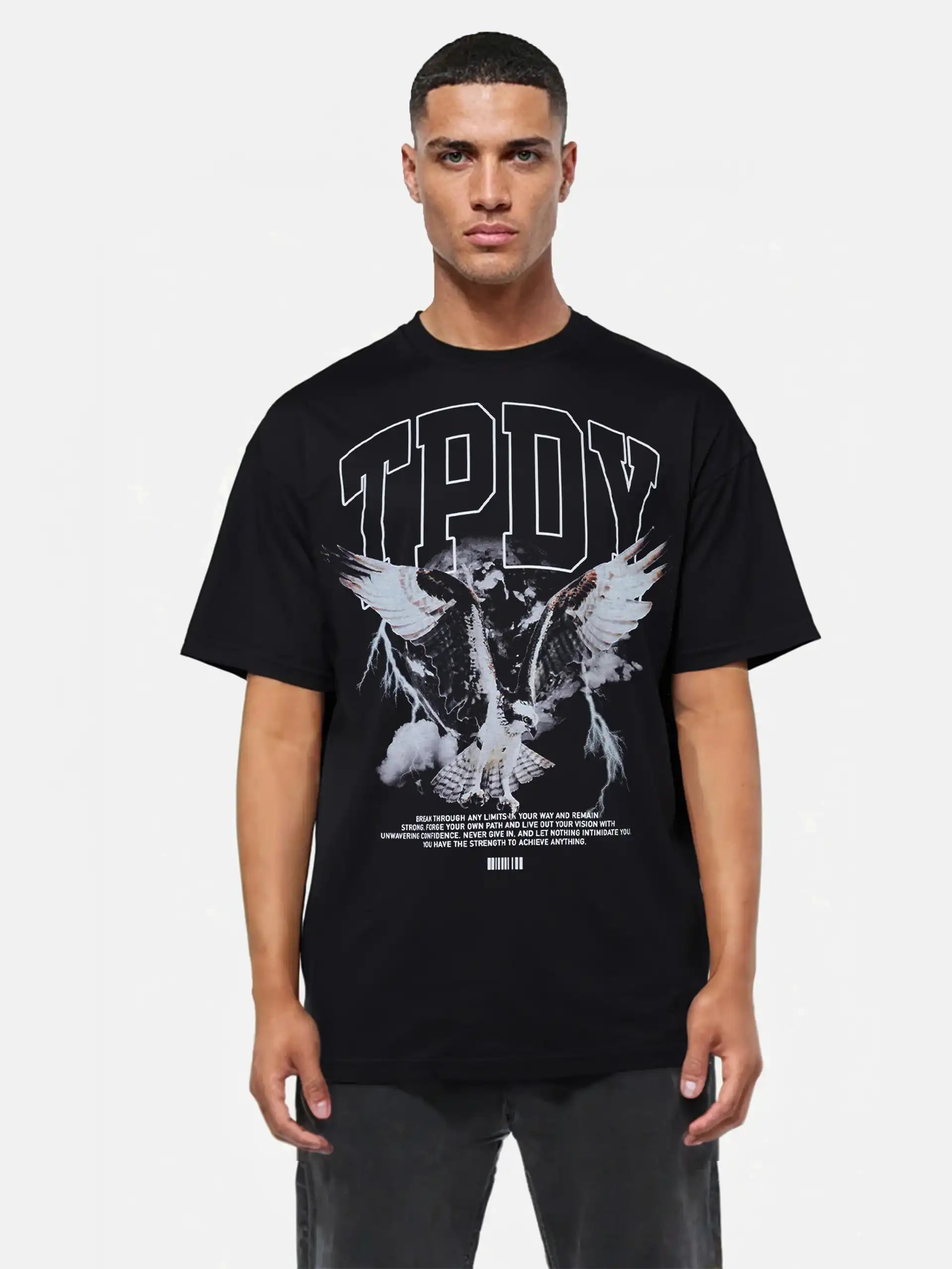 Ein Mann blickt nach vorne in einem schwarzen Yuki Oversize-T-Shirt mit Adlergrafik & TPDY-Schriftzug von trueprodigy. Unter dem fetten "TPDY"-Schriftzug ist ein illustrierter Adler mit ausgebreiteten Flügeln aufgedruckt. Der Hintergrund ist einfarbig weiß.