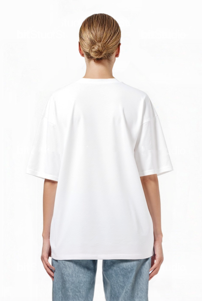 Eine Person mit blonden Haaren in einem tiefen Dutt ist von hinten zu sehen. Sie trägt ein trueprodigy Oversize-T-Shirt mit Adlergrafik & TRUEPRODIGY-Schriftzug und blaue Jeans und steht vor einem schlichten weißen Hintergrund.