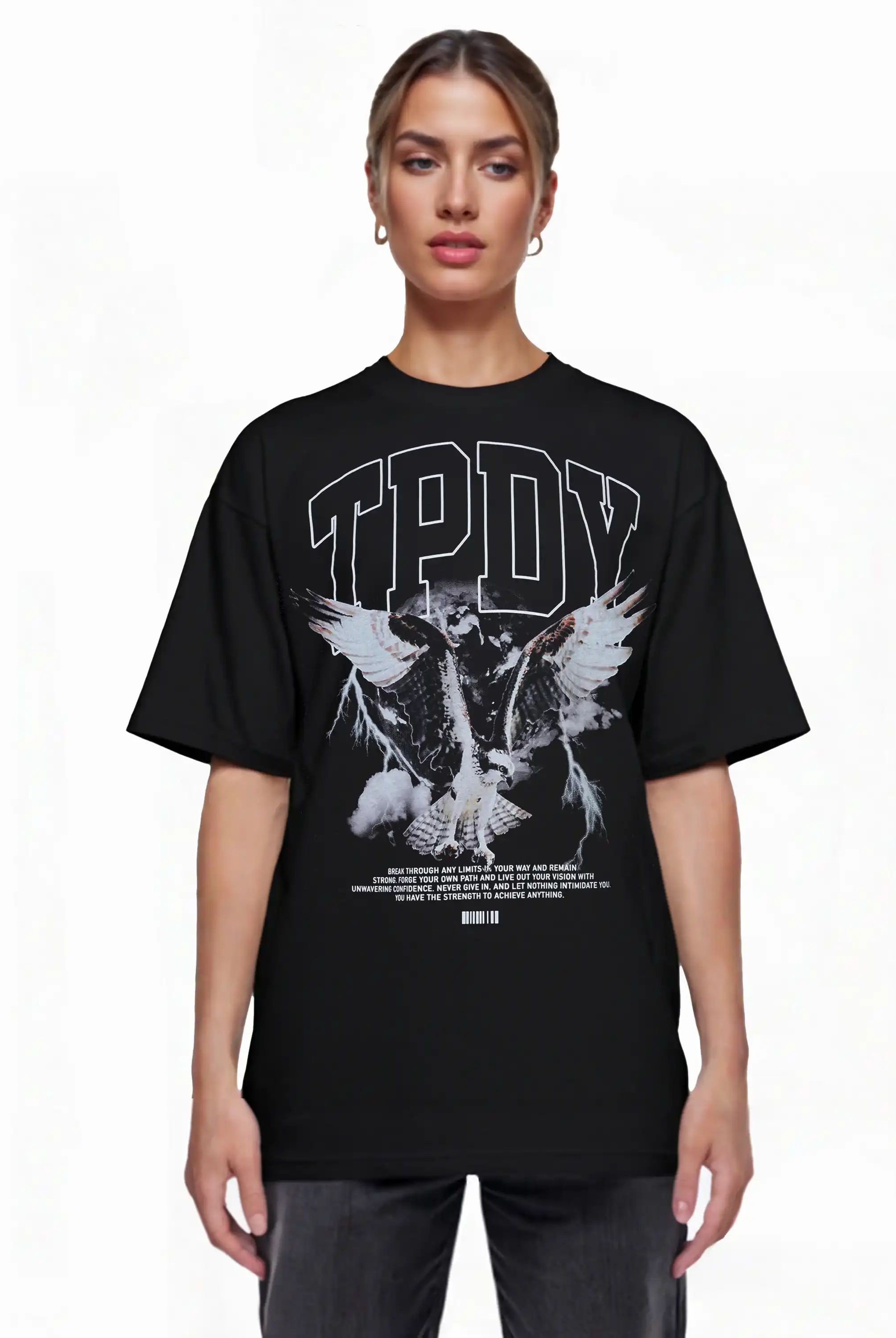 Eine Person steht mit Blick nach vorne in einem trueprodigy Oversize-T-Shirt mit Adlergrafik & TRUEPRODIGY-Schriftzug: loser schwarzer Jersey, "TPDY" in großen weißen Buchstaben, Vogelgrafik mit ausgebreiteten Flügeln, kleiner weißer Text und ein Barcode am unteren Rand.