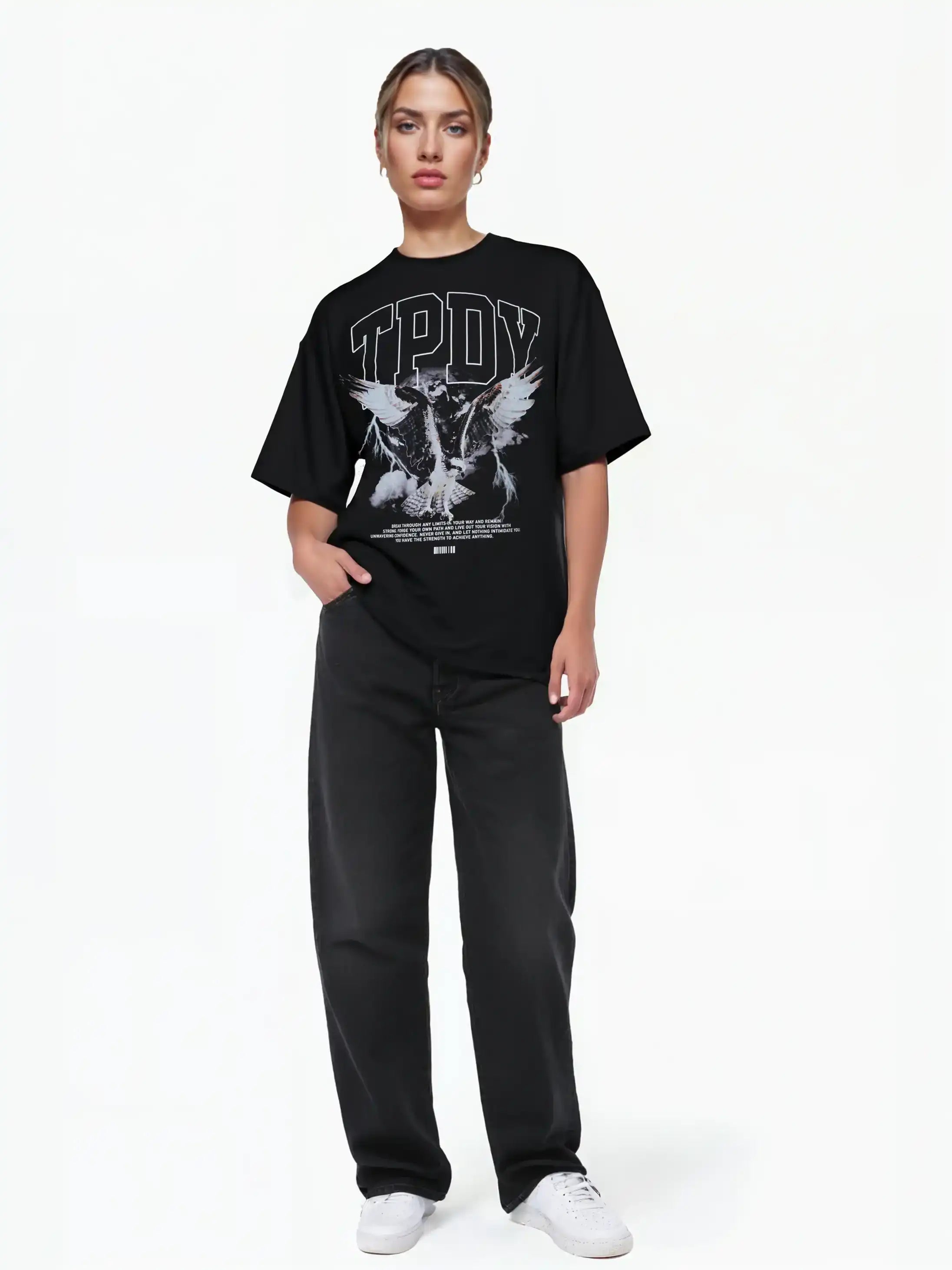 Eine Person steht mit dem Gesicht nach vorne, eine Hand in der Tasche, und trägt ein trueprodigy Oversize-T-Shirt mit Adlergrafik & TRUEPRODIGY-Schriftzug, gepaart mit schwarzen Jeans und weißen Turnschuhen vor einem schlichten weißen Hintergrund.