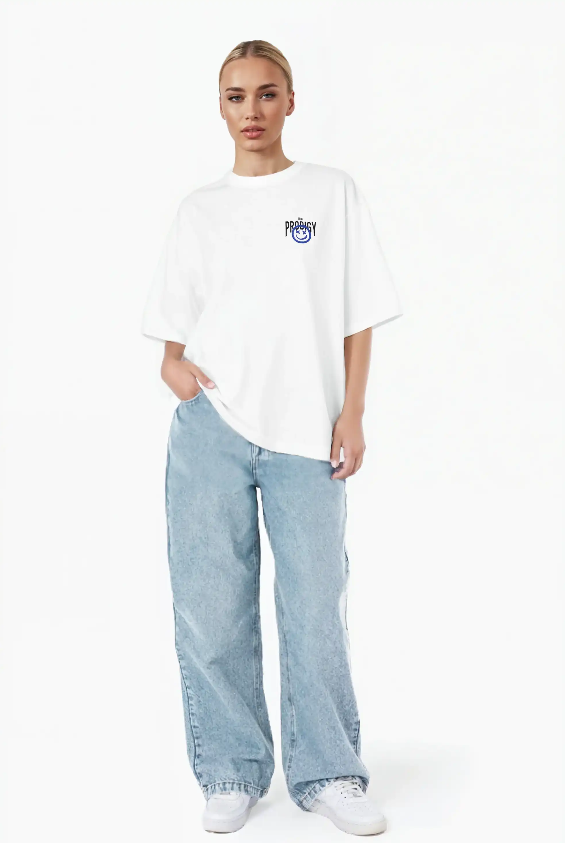 Eine Person steht vor einem weißen Hintergrund und trägt das trueprodigy Hajin F Oversize-T-Shirt mit Spray-Smiley & Happy-Mind-Print, hellblaue Baggy-Jeans und weiße Turnschuhe. Eine Hand steckt in der Tasche.
