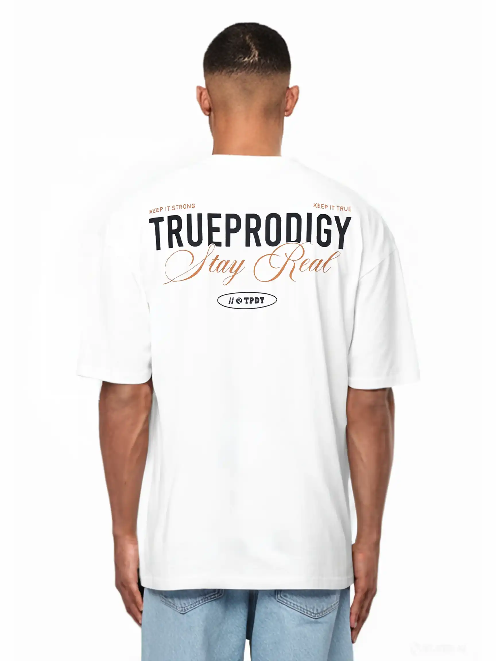 Eine Person schaut weg und trägt das trueprodigy Lou Oversize-T-Shirt aus schwerem Jerseystoff mit auffälligen "Stay Real"- und Schriftzug-Prints auf Vorder- und Rückseite, gepaart mit hellen Denim-Shorts.