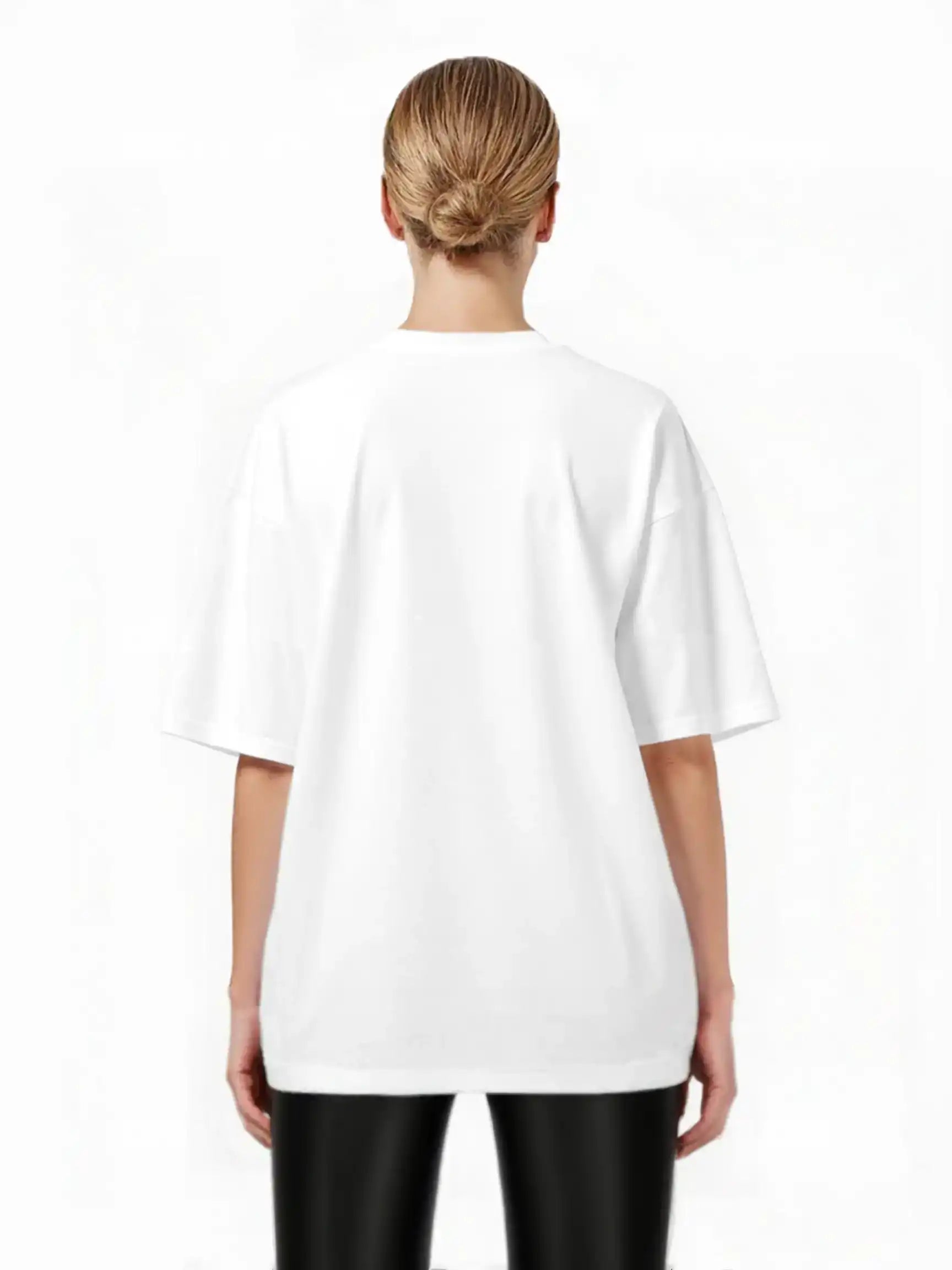 Eine Person mit blonden Haaren in einem gepflegten Dutt steht mit dem trueprodigy Jamie F Oversize-T-Shirt mit Skulptur-Grafik, Schlange & "Fear Nothing"-Print und schwarzer Hose vor einem weißen Hintergrund.