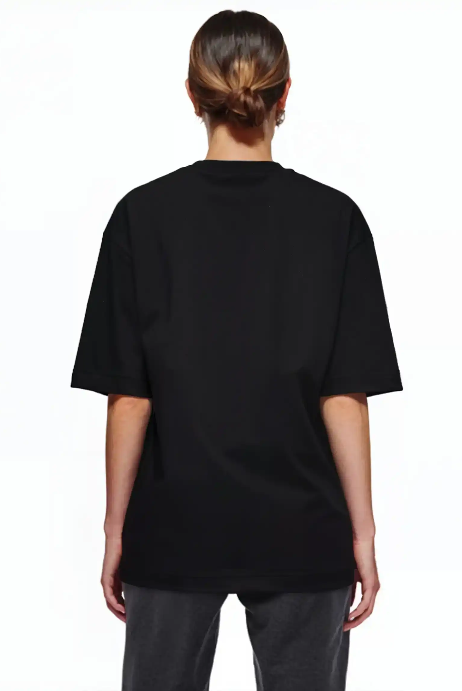 Eine Person schaut von der Kamera weg und trägt das trueprodigy Jamie F Oversize-T-Shirt mit Skulptur-Grafik, Schlange & "Fear Nothing"-Print in schwarz mit dunkelgrauer Hose. Ihre Haare sind vor einem schlichten weißen Hintergrund nach hinten gezogen.