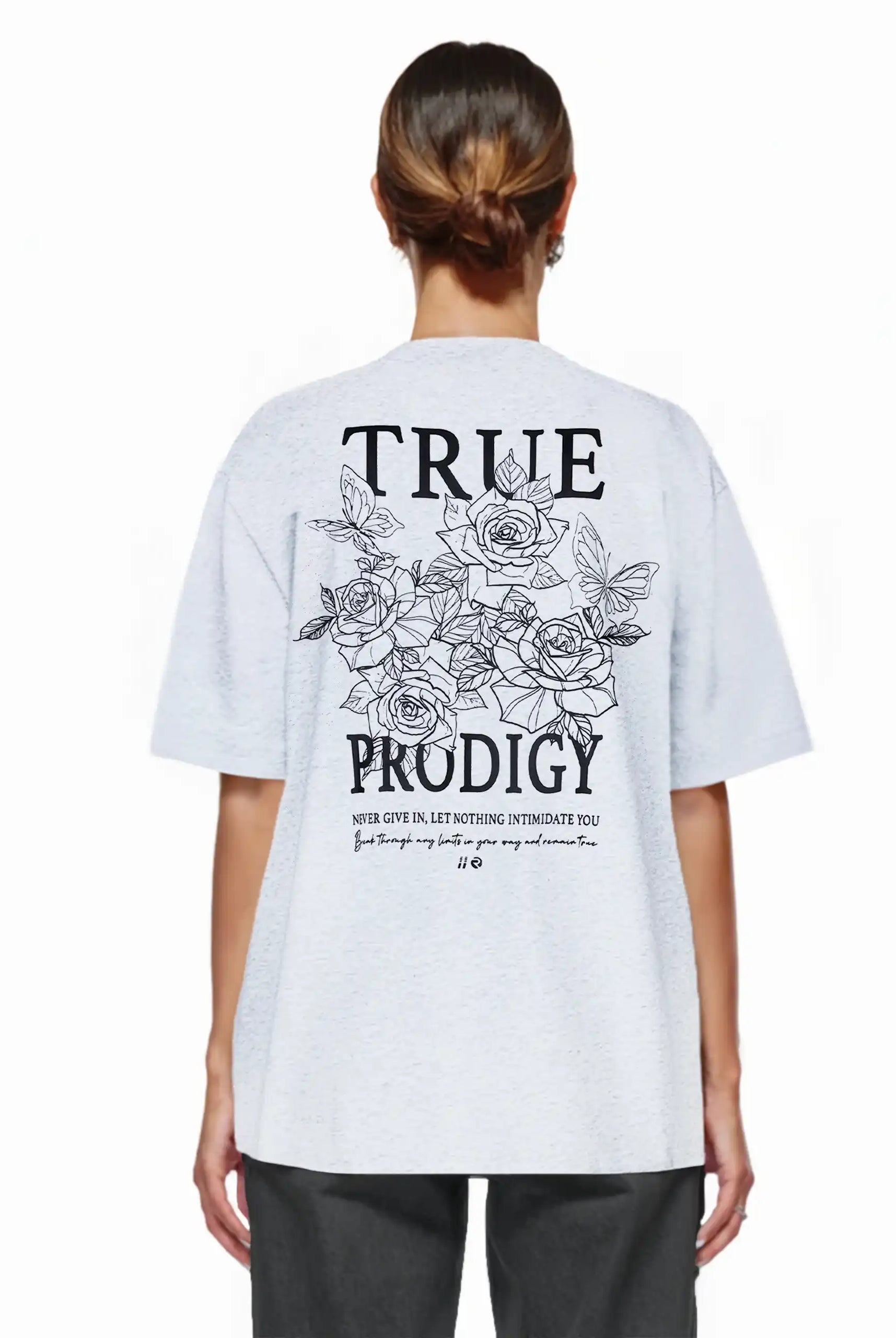 Eine Frau mit braunen Haaren in einem tiefen Dutt trägt das trueprodigy Alex F Oversize-T-Shirt mit Spray-Smiley und trueprodigy-Logo auf Vorder- und Rückseite aus dickem Jersey-Stoff.