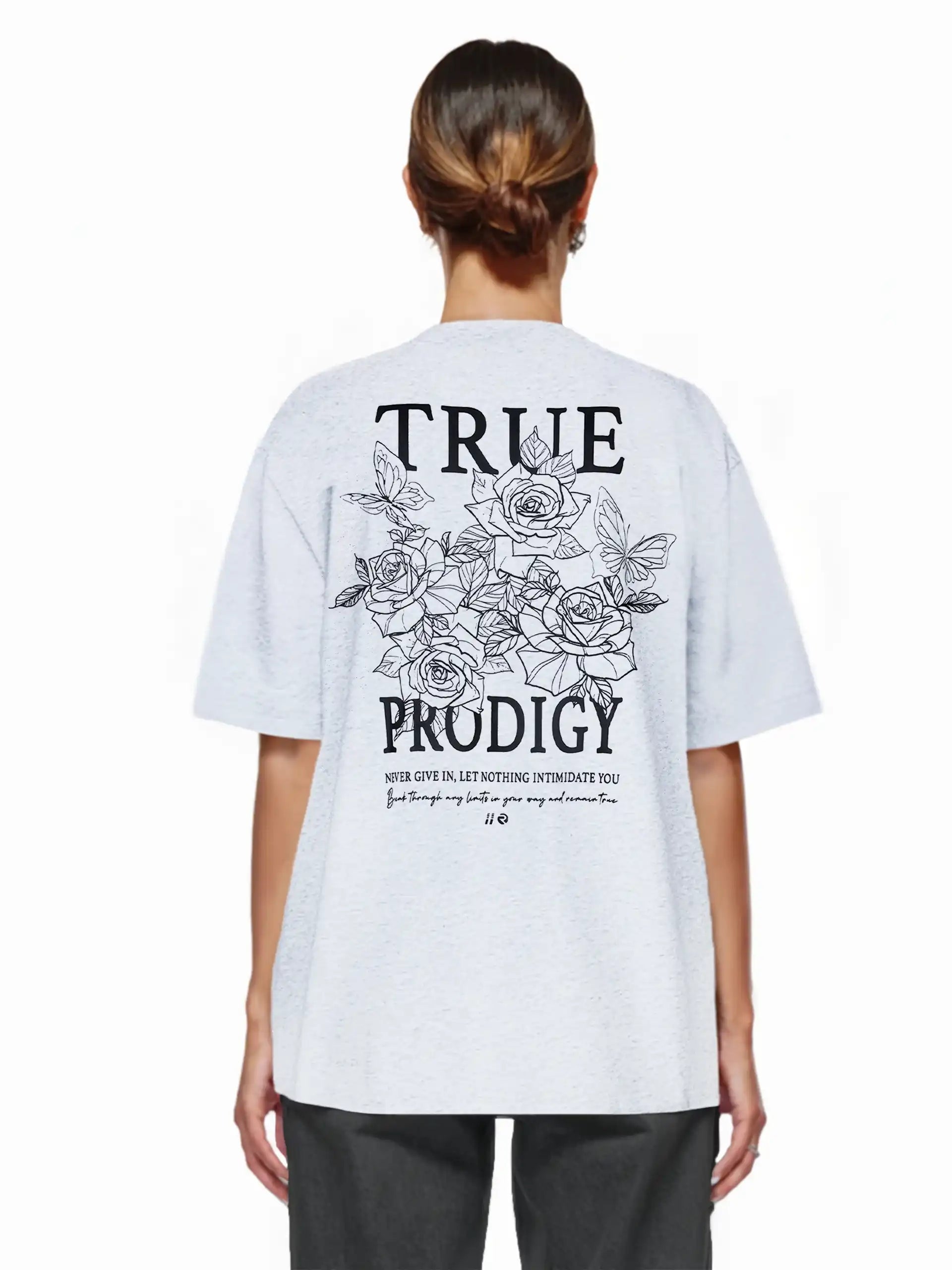 Eine Frau mit braunen Haaren in einem tiefen Dutt trägt das trueprodigy Alex F Oversize-T-Shirt mit Spray-Smiley und trueprodigy-Logo auf Vorder- und Rückseite aus dickem Jersey-Stoff.