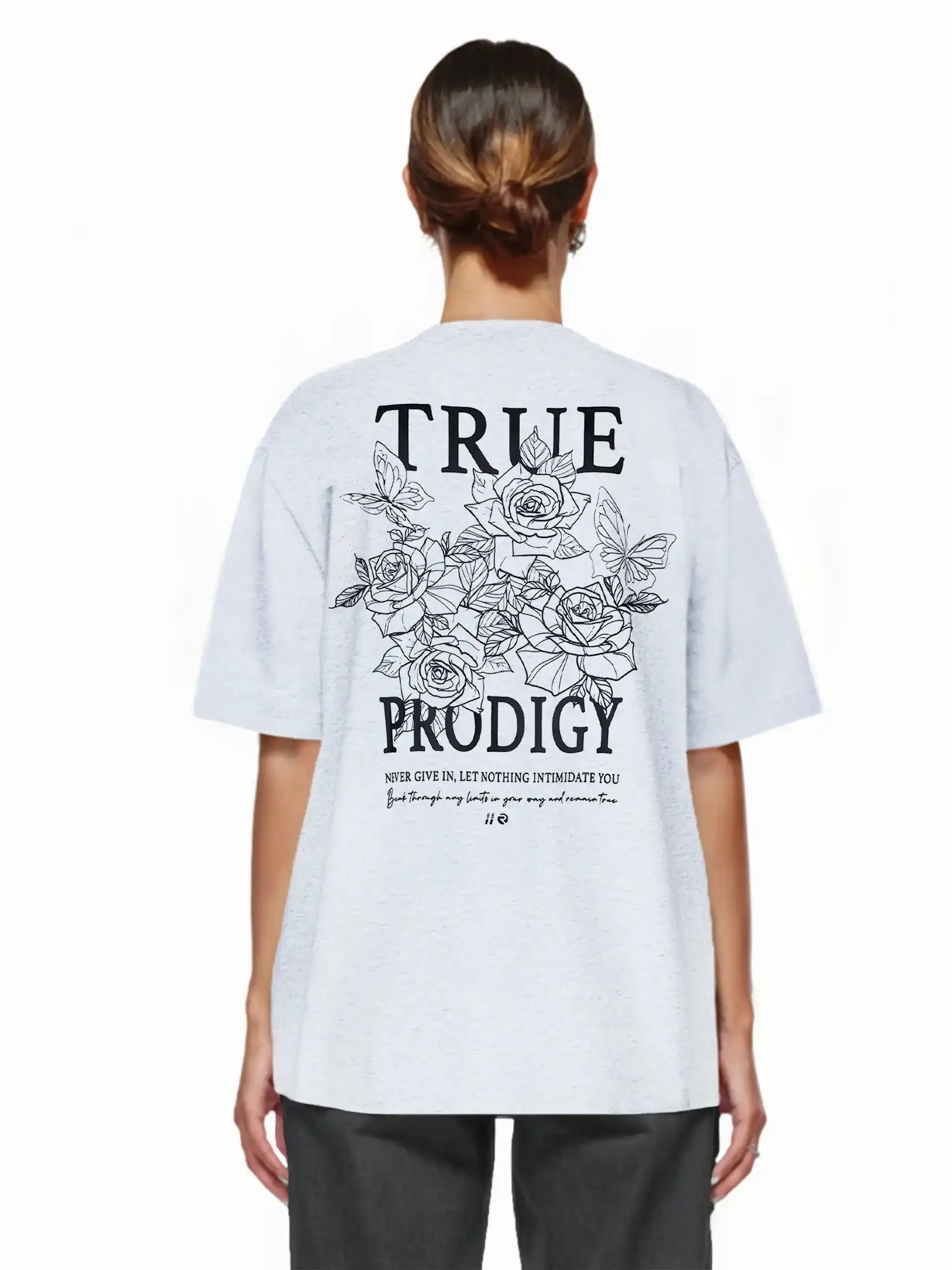 Eine Frau mit braunen Haaren in einem tiefen Dutt trägt das trueprodigy Alex F Oversize-T-Shirt mit Spray-Smiley und trueprodigy-Logo auf Vorder- und Rückseite aus dickem Jersey-Stoff.