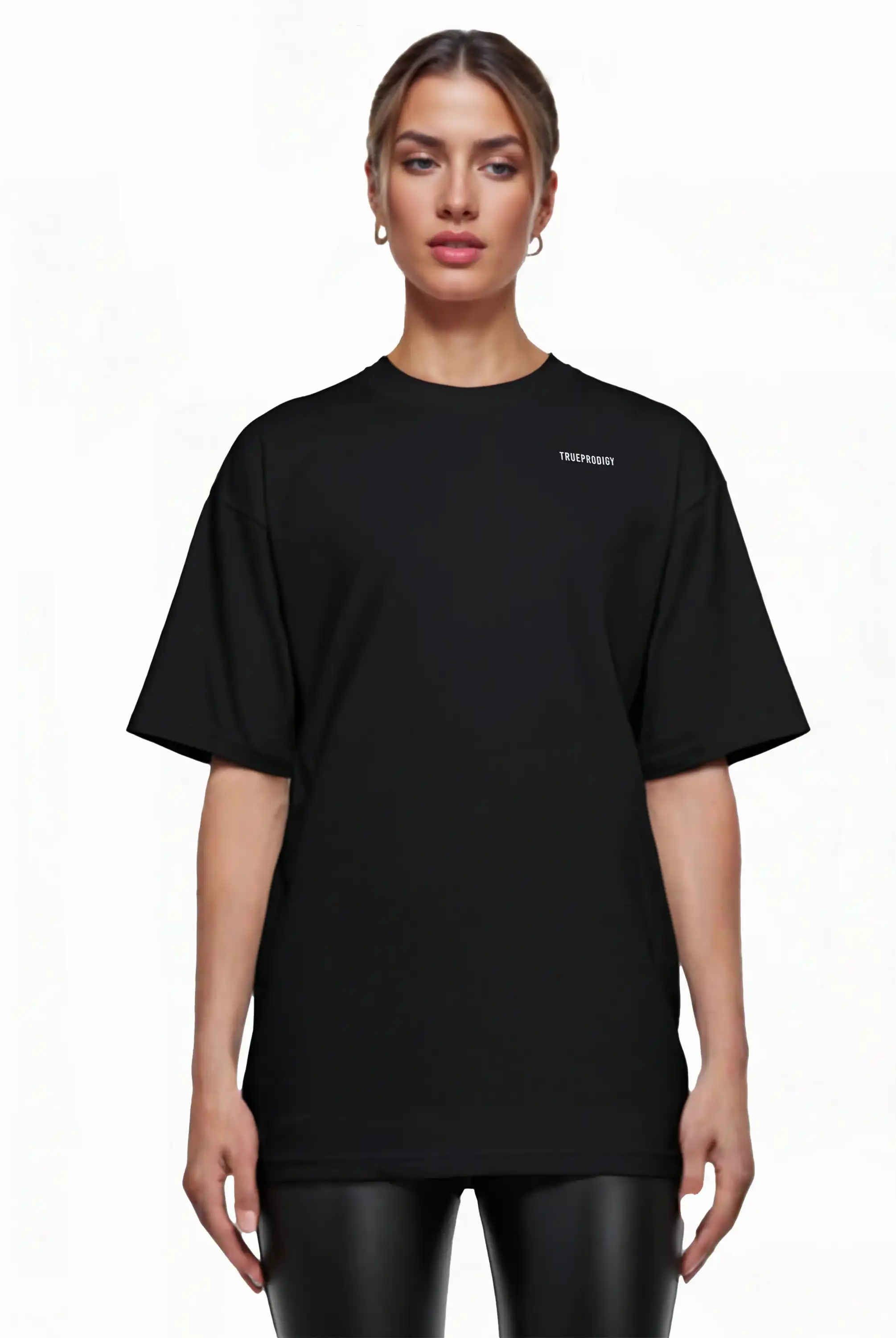 Eine Person steht in einem lockeren Lior F Oversize-Damen-T-Shirt von trueprodigy mit Rückenstatement "never back down", gepaart mit einer schwarzen Hose in Lederoptik, vor einem schlichten weißen Hintergrund.