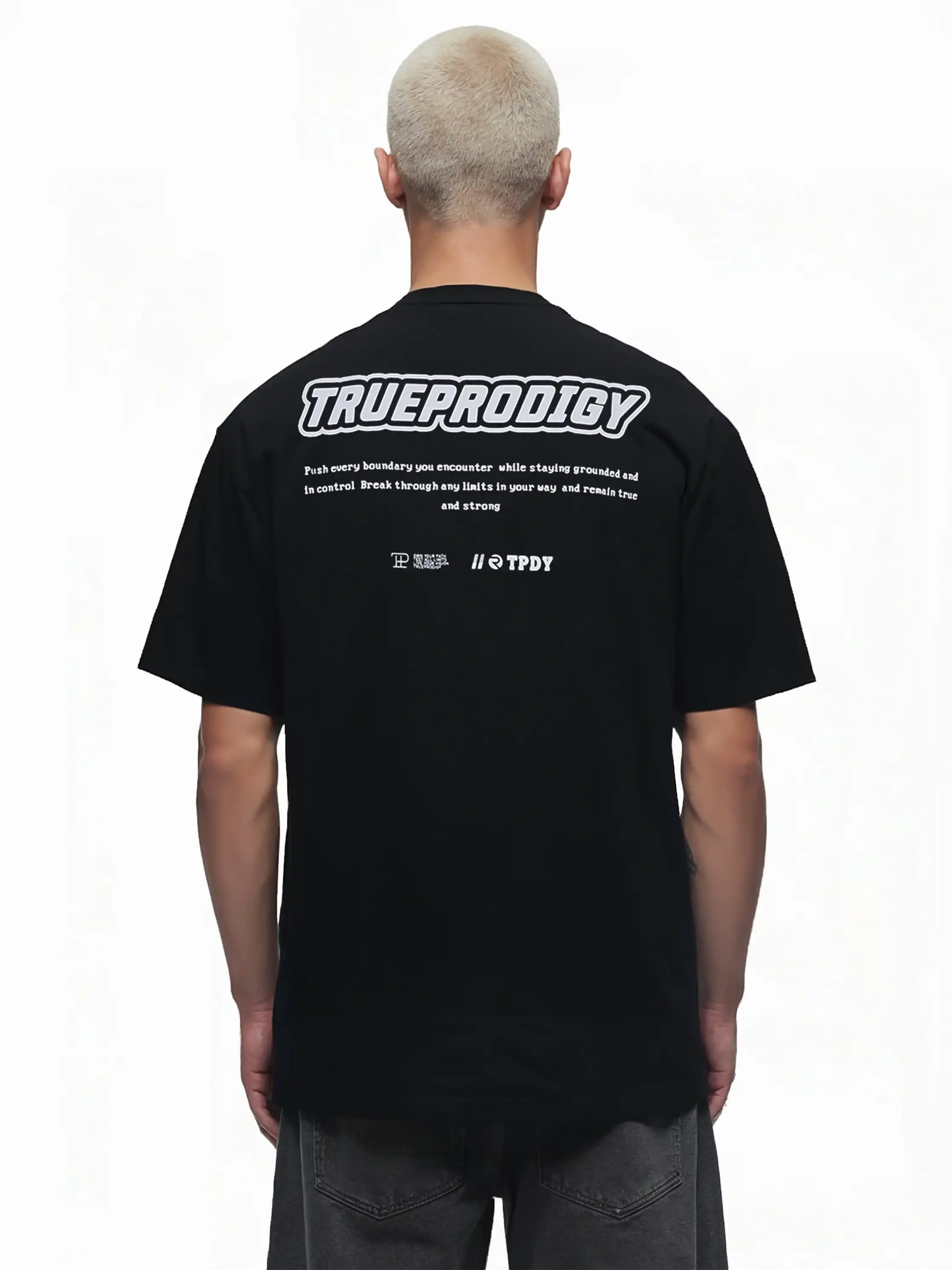 Eine Person mit kurzen Haaren ist von hinten zu sehen. Sie trägt das Eden Oversize-Shirt von trueprodigy mit einem 3D-Logo-Schaumstoffdruck auf der Brust und dem Rücken vor einem schlichten weißen Hintergrund.