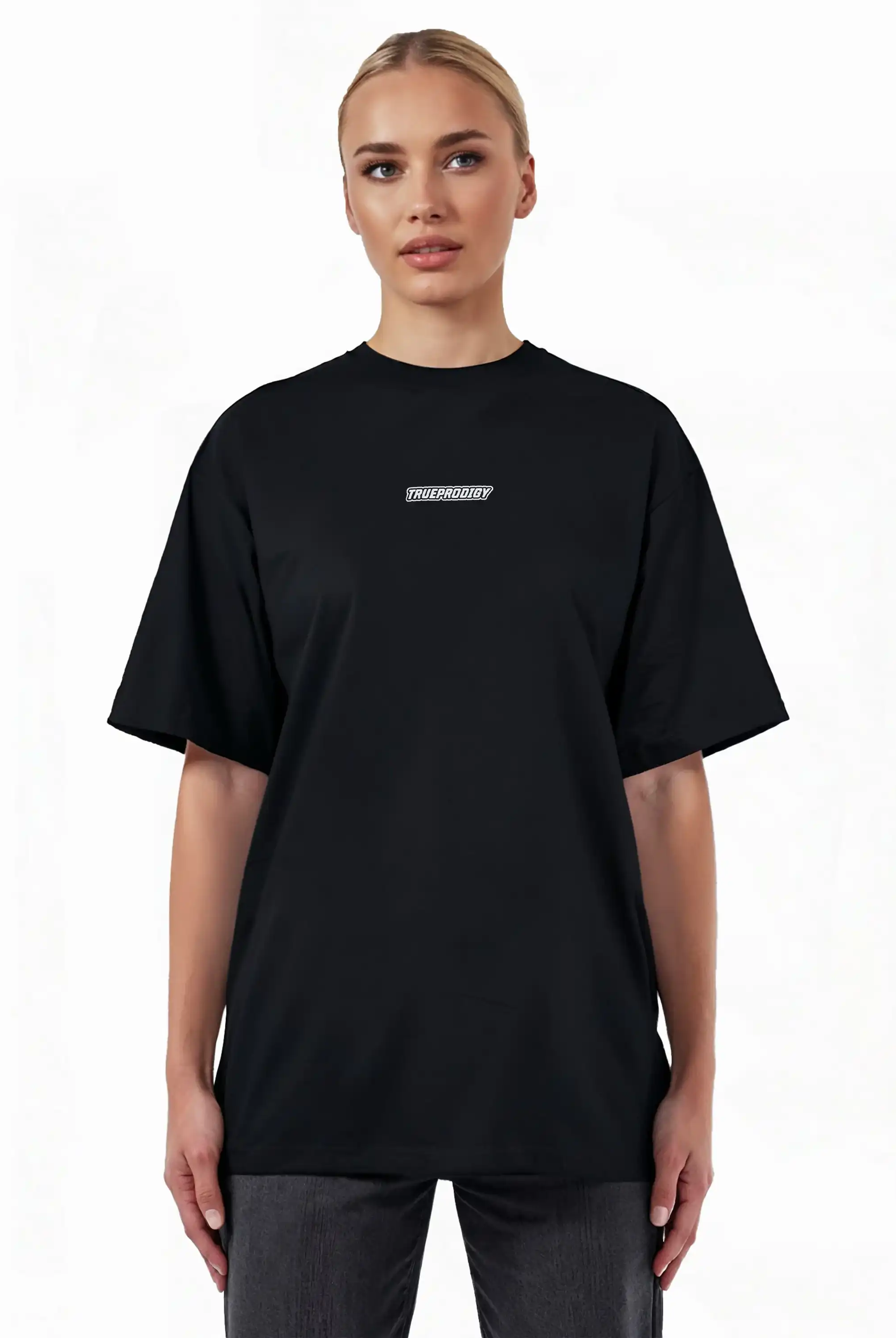 Eine Person steht mit dem Blick nach vorne und trägt das trueprodigy Eden F Oversize-T-Shirt mit 3D-Logo-Schriftzug vorn & großem Rückenprint in schwarz mit kurzen Ärmeln, gepaart mit einer dunklen Hose, vor einem weißen Hintergrund.