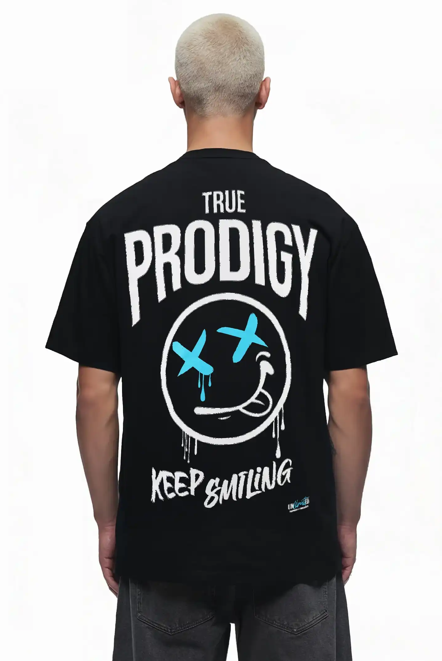 Eine Person mit kurzen, hellen Haaren ist von hinten zu sehen. Sie trägt das trueprodigy Kenji Oversize-T-Shirt mit einem auffälligen weiß-blauen Smiley-Gesicht und dem Text "TRUE PRODIGY KEEP SMILING" als großen Rückenaufdruck.