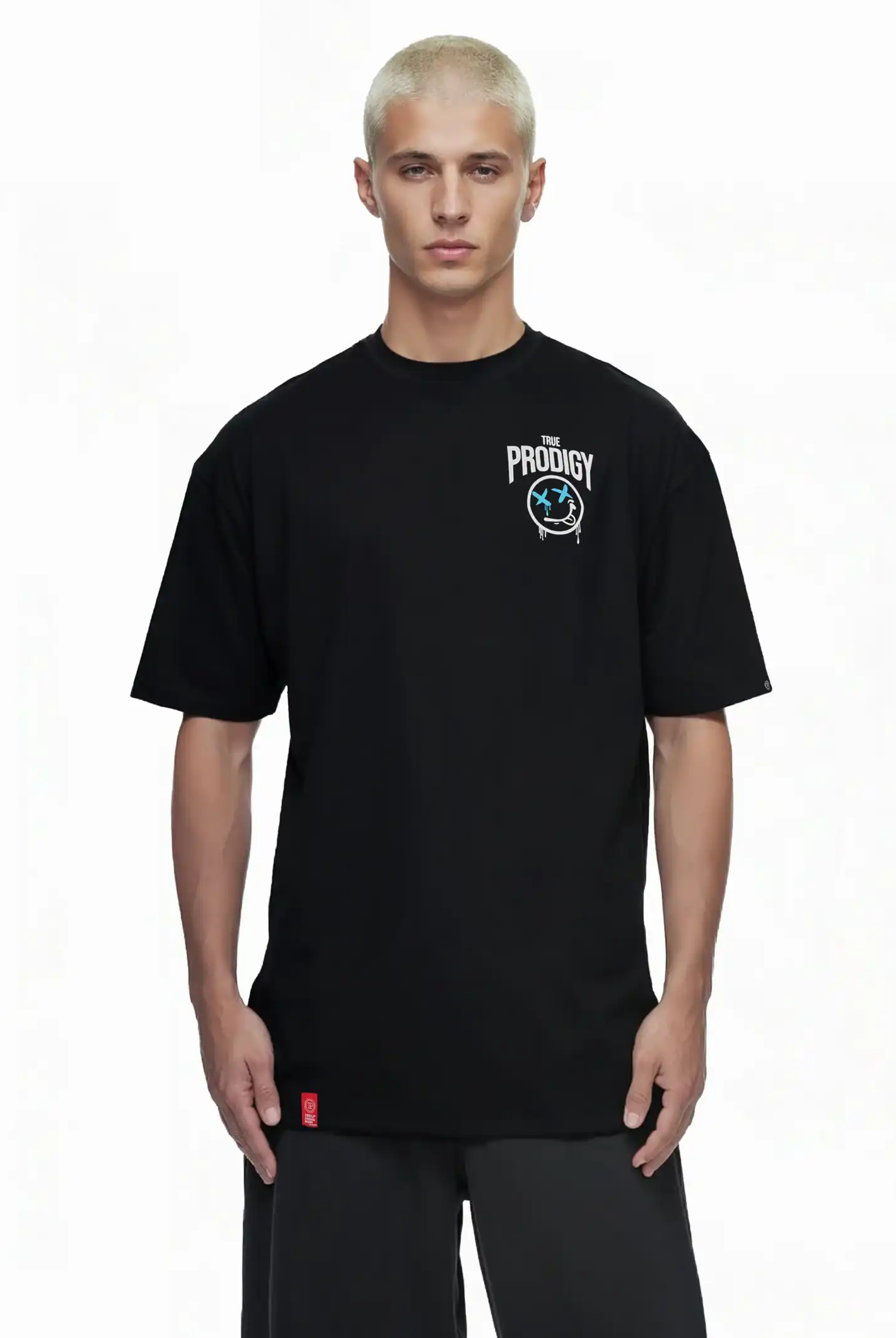 Eine Person mit kurzen platinblonden Haaren trägt das trueprodigy Kenji Oversize-T-Shirt mit Brustprint und großem Rückenmotiv, stehend vor einem schlichten weißen Hintergrund.