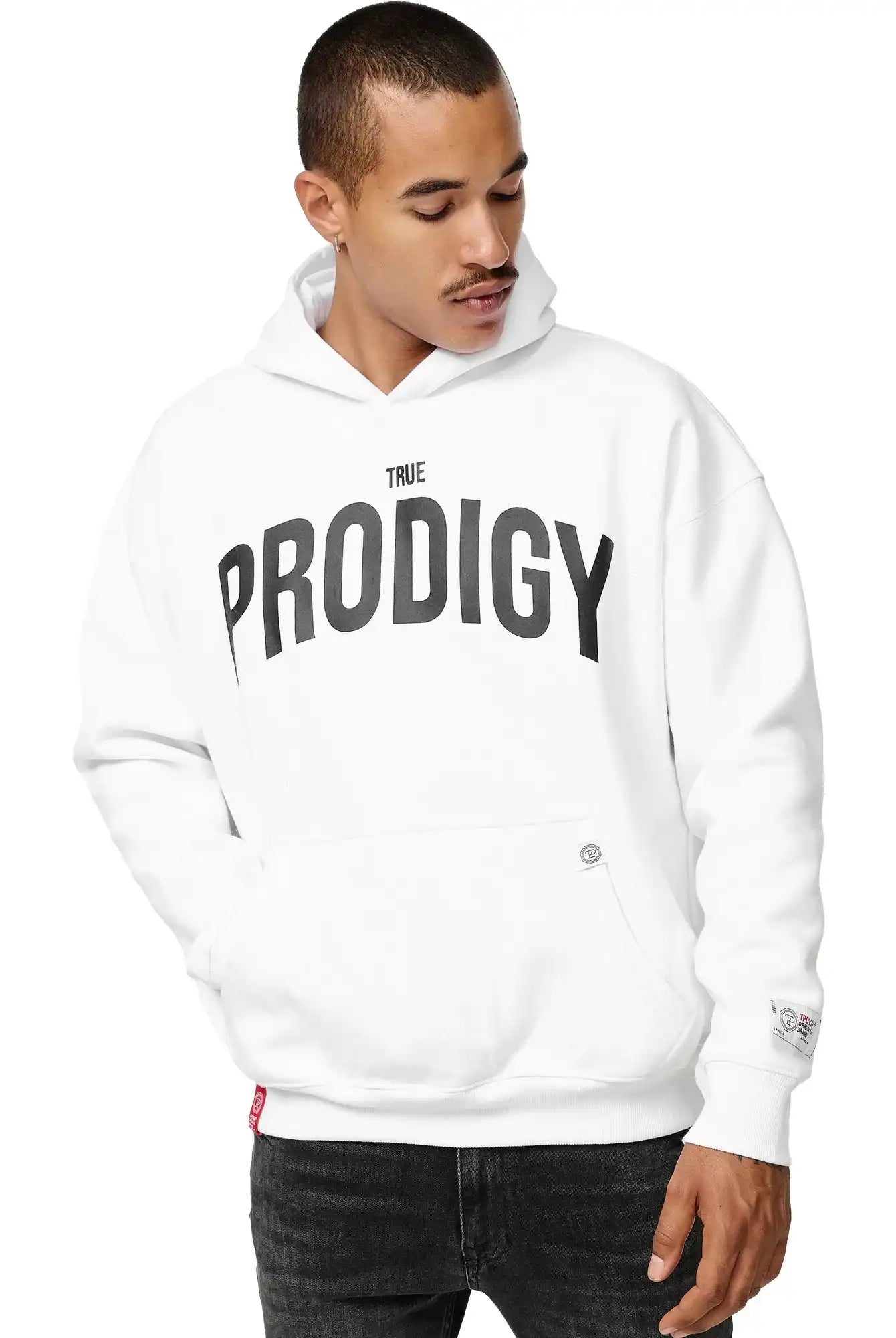 Eine Person, die den trueprodigy Tobi Oversized Hoodie mit Print in Weiß mit einem auffälligen TRUE PRODIGY Print auf der Vorderseite trägt, schaut mit einer Hand in der Tasche nach unten.