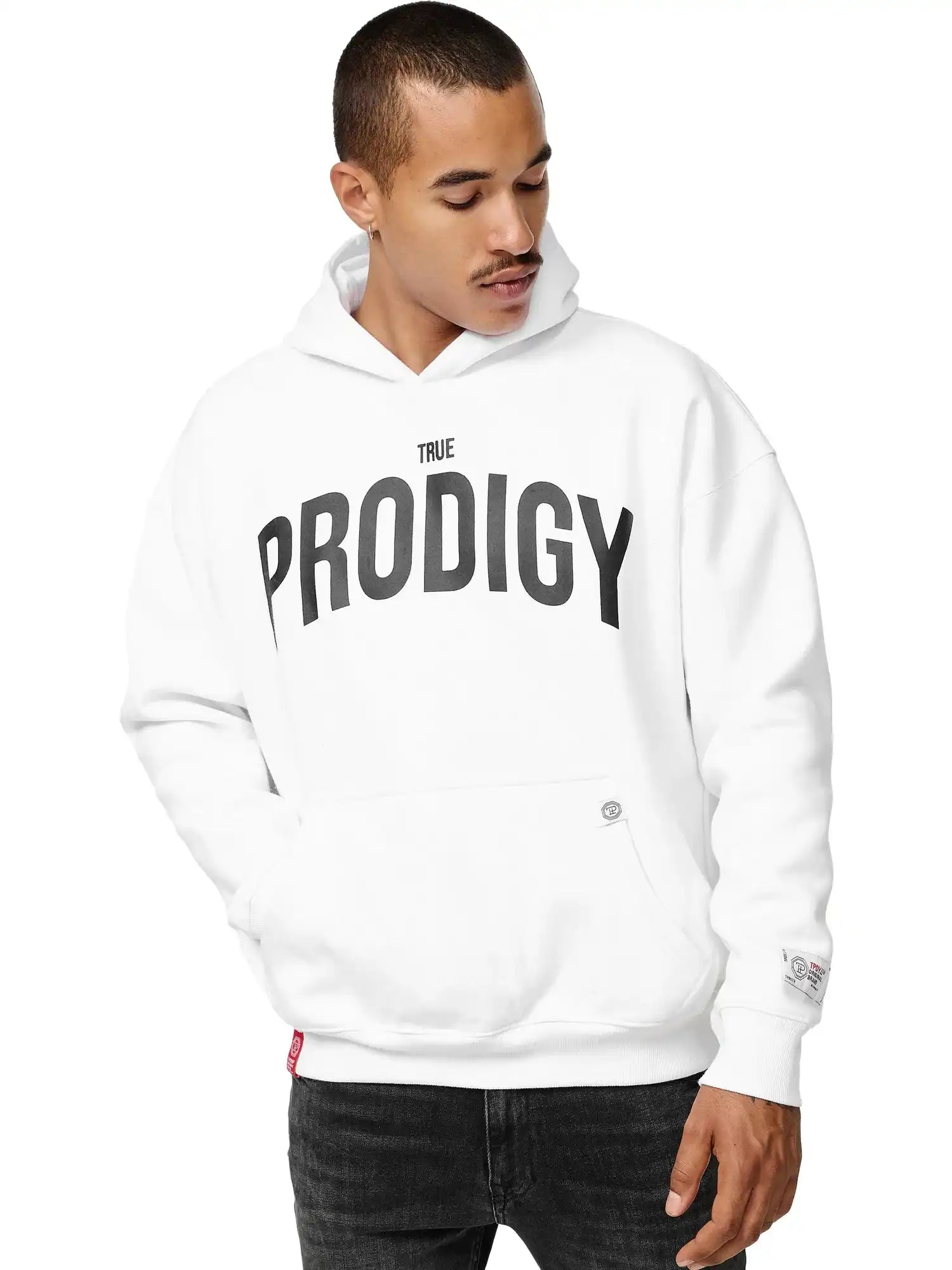 Eine Person, die den trueprodigy Tobi Oversized Hoodie mit Print in Weiß mit einem auffälligen TRUE PRODIGY Print auf der Vorderseite trägt, schaut mit einer Hand in der Tasche nach unten.