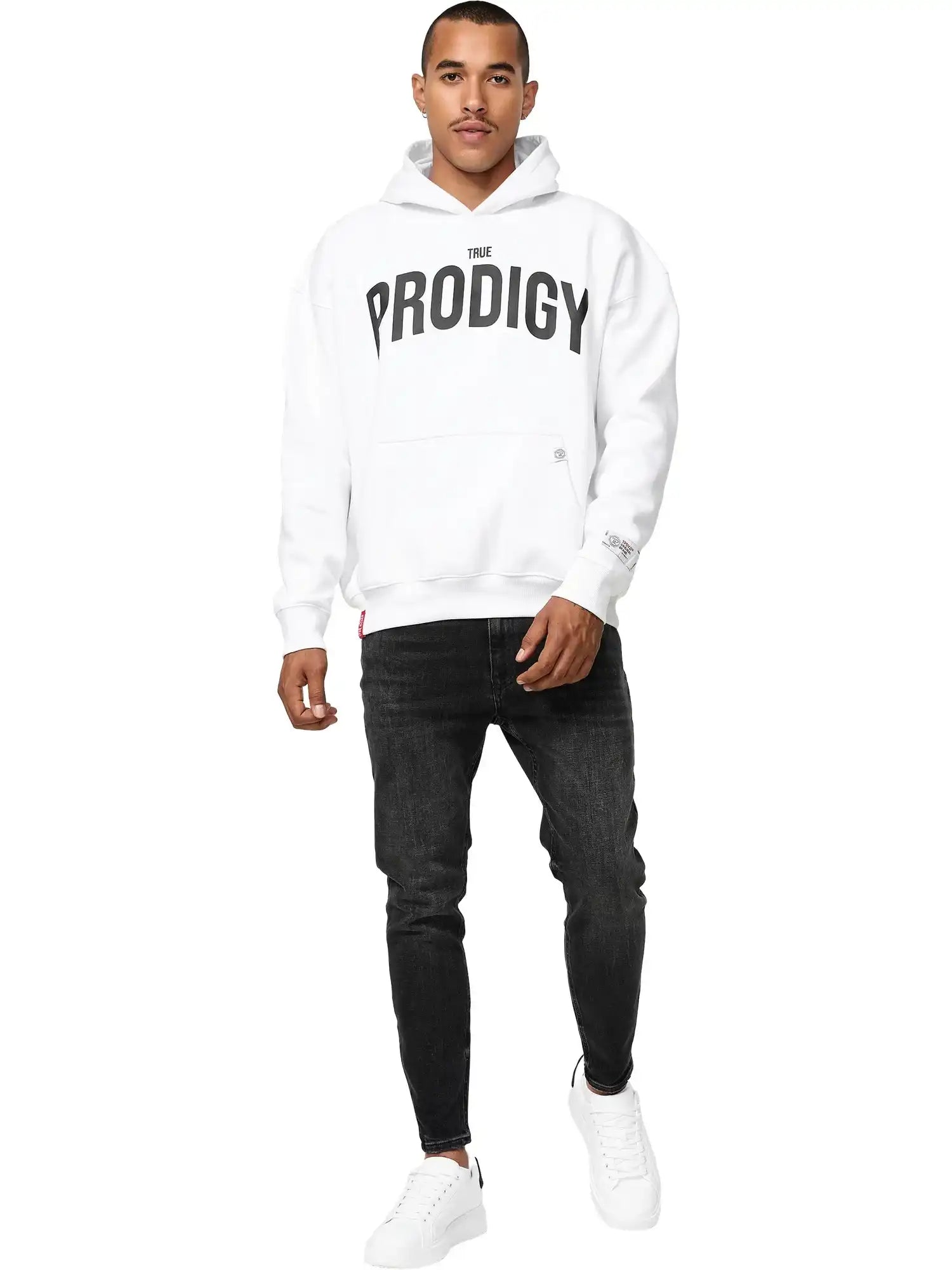 Ein Mann blickt nach vorne in einem trueprodigy Tobi Oversized Hoodie mit Print, mit fetten schwarzen Schriftzügen, gepaart mit schwarzen Jeans und weißen Turnschuhen, vor einem schlichten weißen Hintergrund.