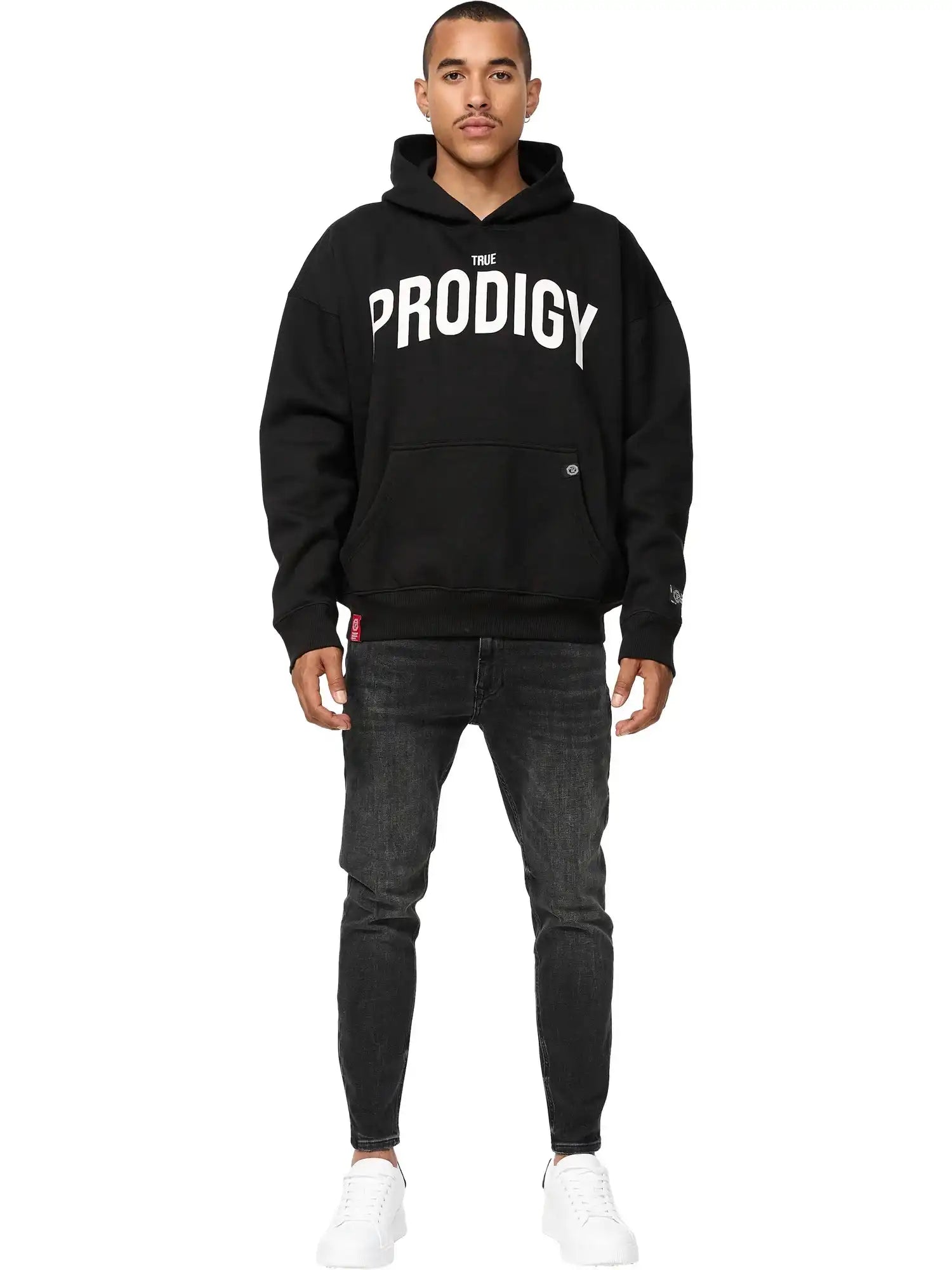 Ein Mann steht mit dem Gesicht nach vorne und trägt einen trueprodigy Tobi Oversized Hoodie mit Print, schwarze Jeans und weiße Turnschuhe vor einem schlichten weißen Hintergrund.