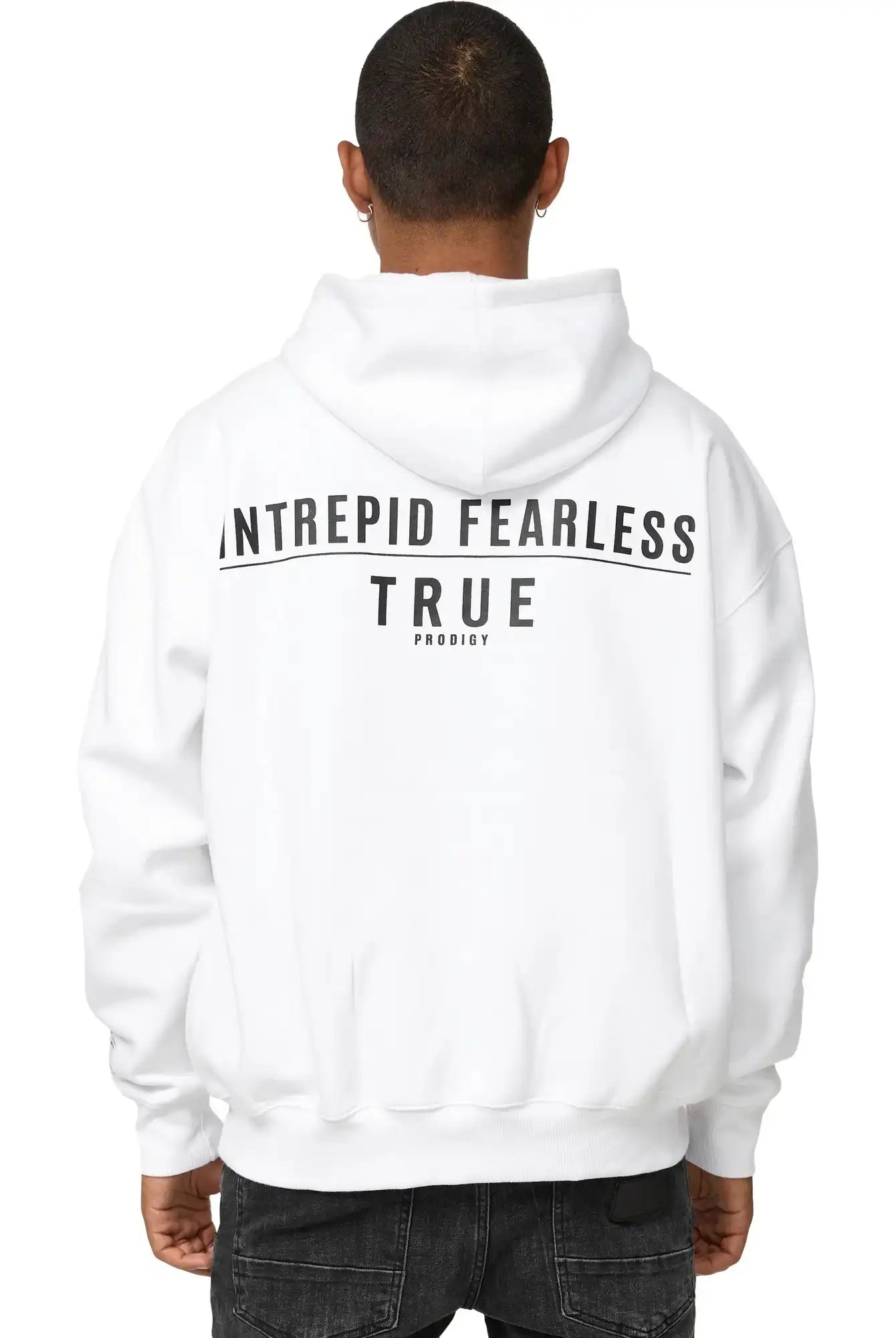 Eine Person mit kurzen Haaren ist von hinten zu sehen. Sie trägt den trueprodigy Aaren Oversized Hoodie mit Print, mit "INTREPID FEARLESS TRUE PRODIGY" in schwarzer Schrift auf dem Rücken, gepaart mit einer schwarzen Jeans.