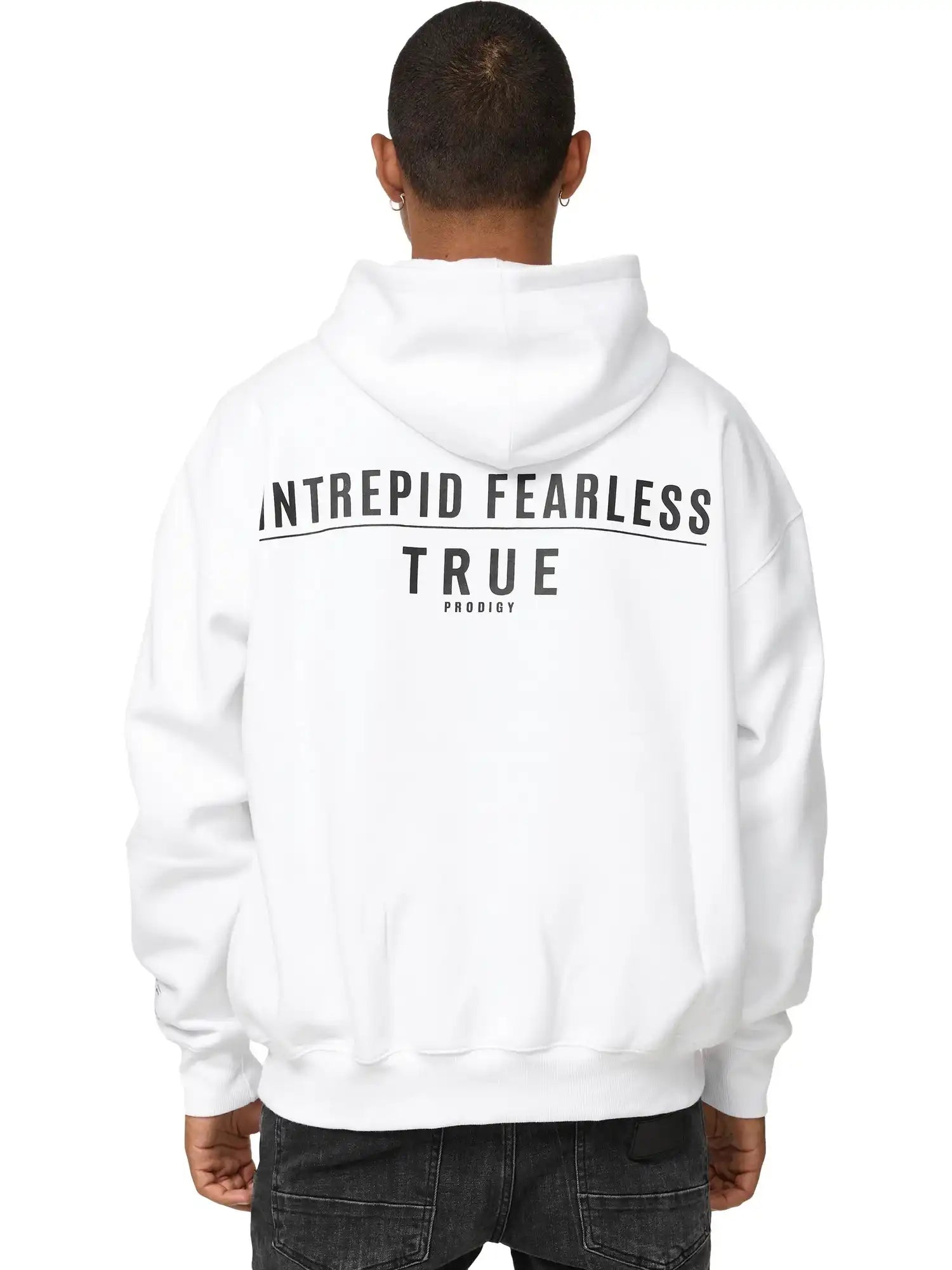 Eine Person mit kurzen Haaren ist von hinten zu sehen. Sie trägt den trueprodigy Aaren Oversized Hoodie mit Print, mit "INTREPID FEARLESS TRUE PRODIGY" in schwarzer Schrift auf dem Rücken, gepaart mit einer schwarzen Jeans.