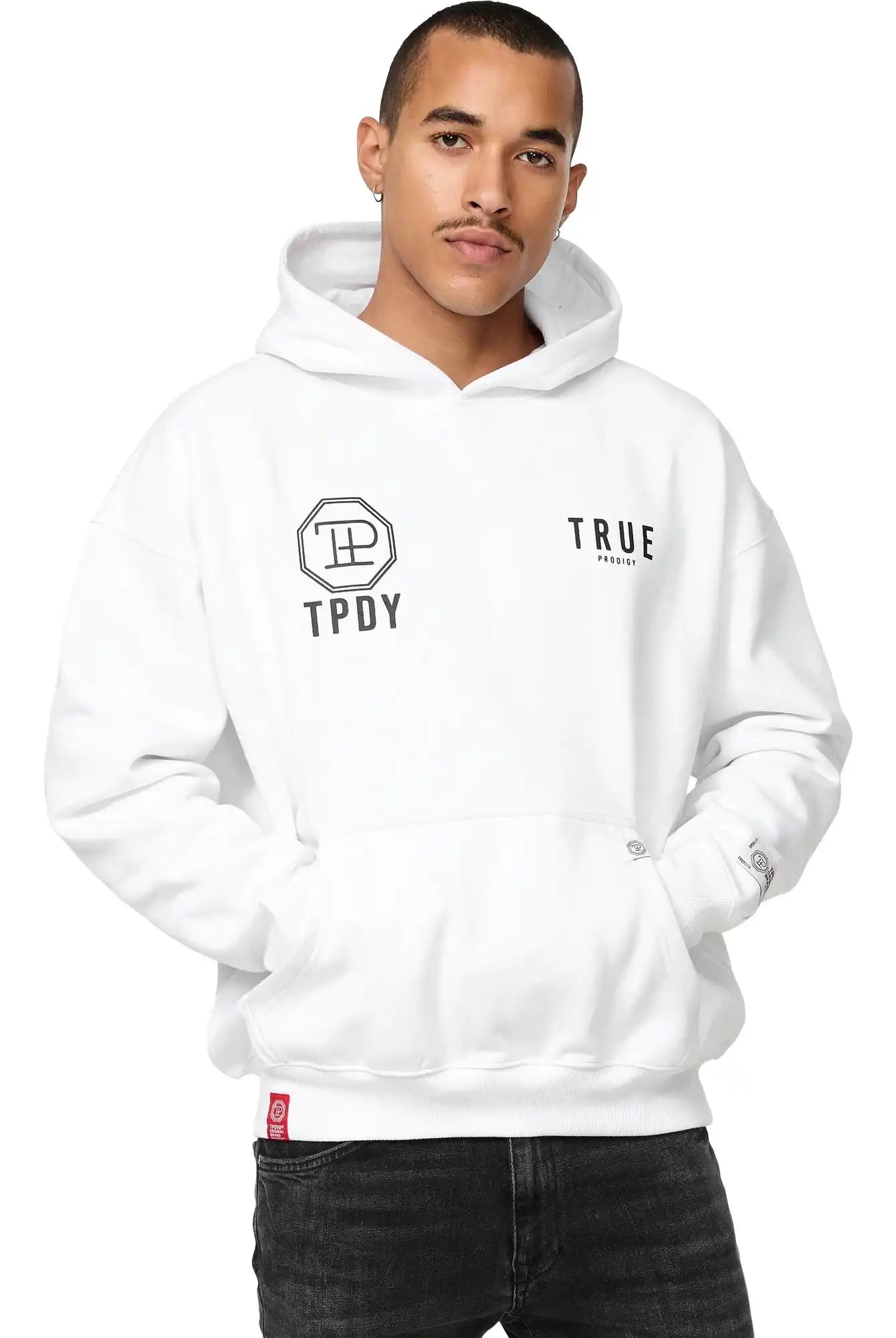 Eine Person mit kurzen Haaren und schwarzen Jeans trägt den trueprodigy Aaren Oversized Hoodie mit Print, mit TPDY und trueprodigy Logos auf der Vorderseite, gestylt mit einer Hand in der Tasche.